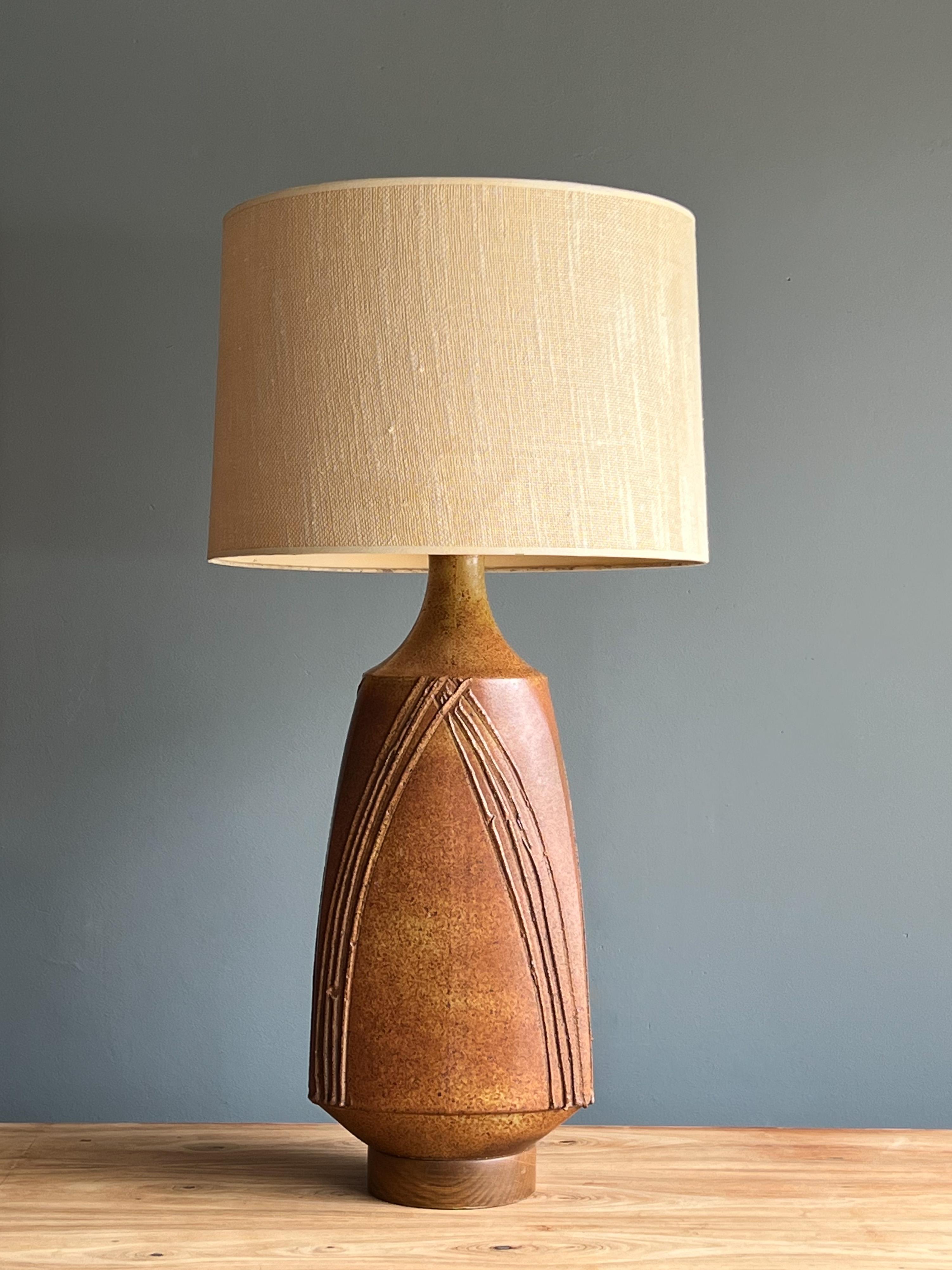Beautiful ceramic table lamp designed by renowned pottery and glaze master David Cressey, California 1960s.

This example features a lovely speckled glaze with a neutral color pallet on top of a walnut base and brass stem. The glaze consists of