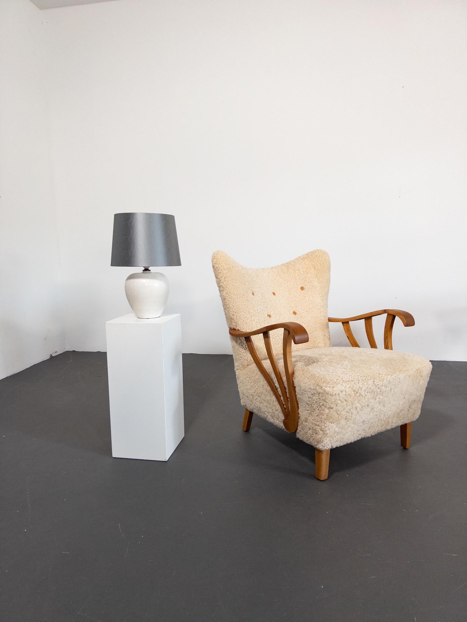 Une lampe de table rare et élégante conçue par le célèbre artiste céramiste suédois Gunnar Nylund pour Rörstrand dans les années 1950. Fabriquée avec le vernis Harpälsglasyr (fourrure de lièvre), cette pièce présente une finition crème doucement