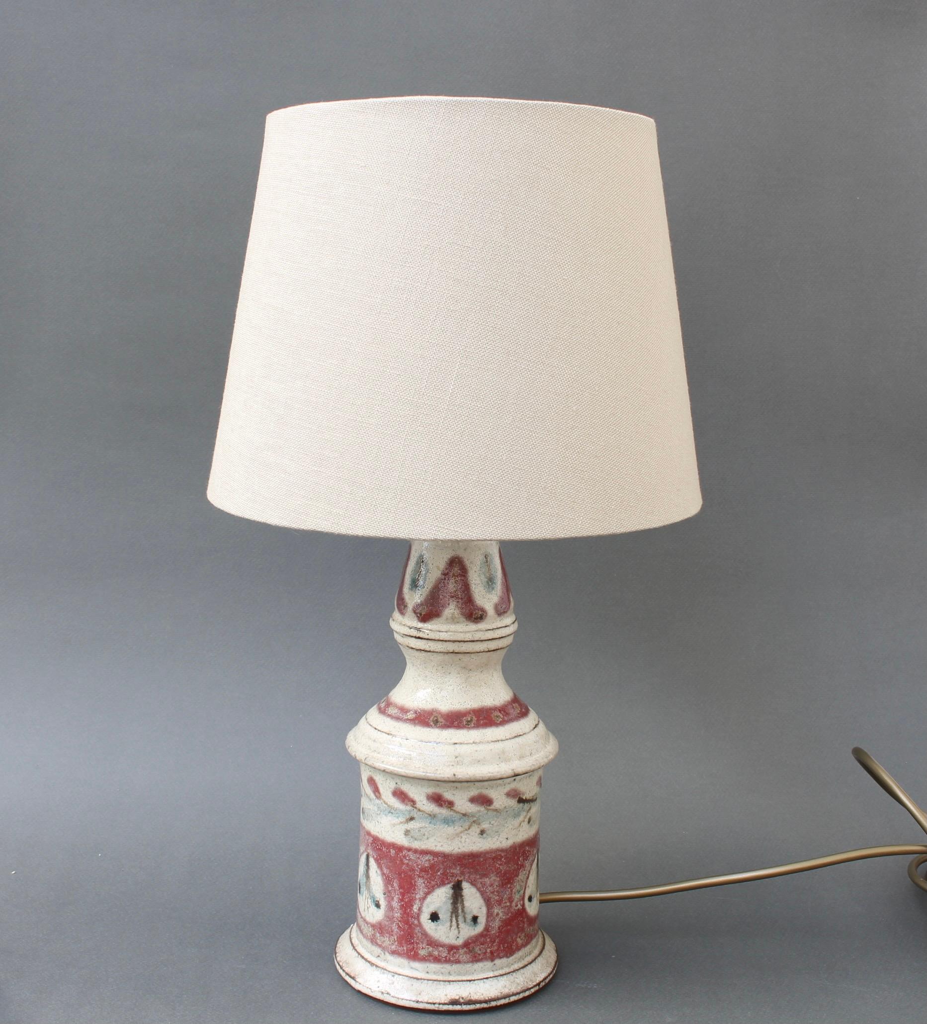 Vintage ceramic table lamp (circa 1960s) by Gustave Reynaud for Le Mûrier. A classic Reynaud design and decoration scheme; the lamp's base colour is done in an oatmeal glaze with painted mulberry coloured bands with light blue accents in the plant