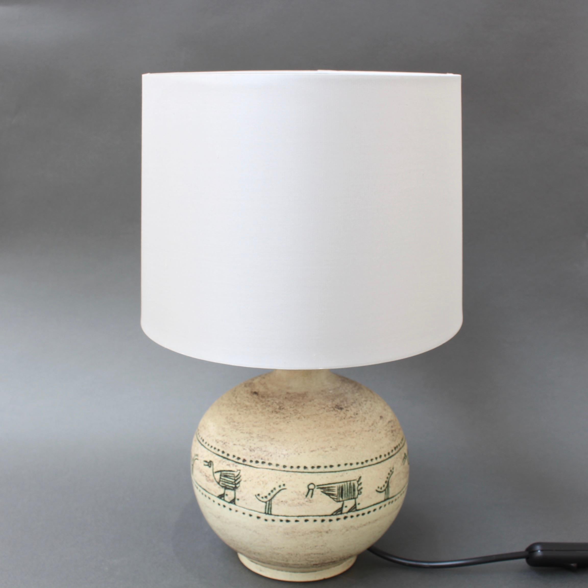 Midcentury ceramic table lamp by Jacques Blin, (circa 1950s). This beautifully off-white lamp with sgraffito-etched fanciful animals and birds over the trademark misty glaze with dusty effect finish is quintessential Jacques Blin. In good condition