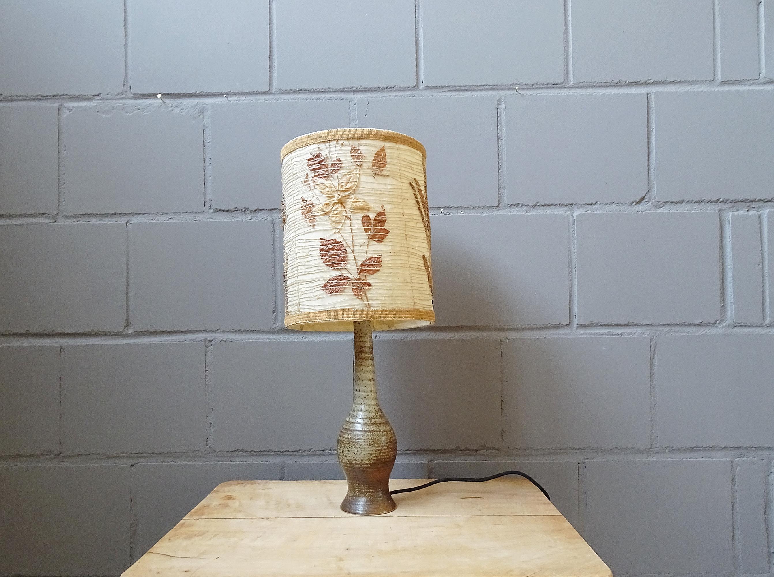 French table lamp from the 1960s-1970s by Jean Tessier Atelier du Cep. Sculptural base made of pyrite sandstone and a large lampshade with various leaves / dried flowers.

A timeless lamp that impresses with its natural materials and