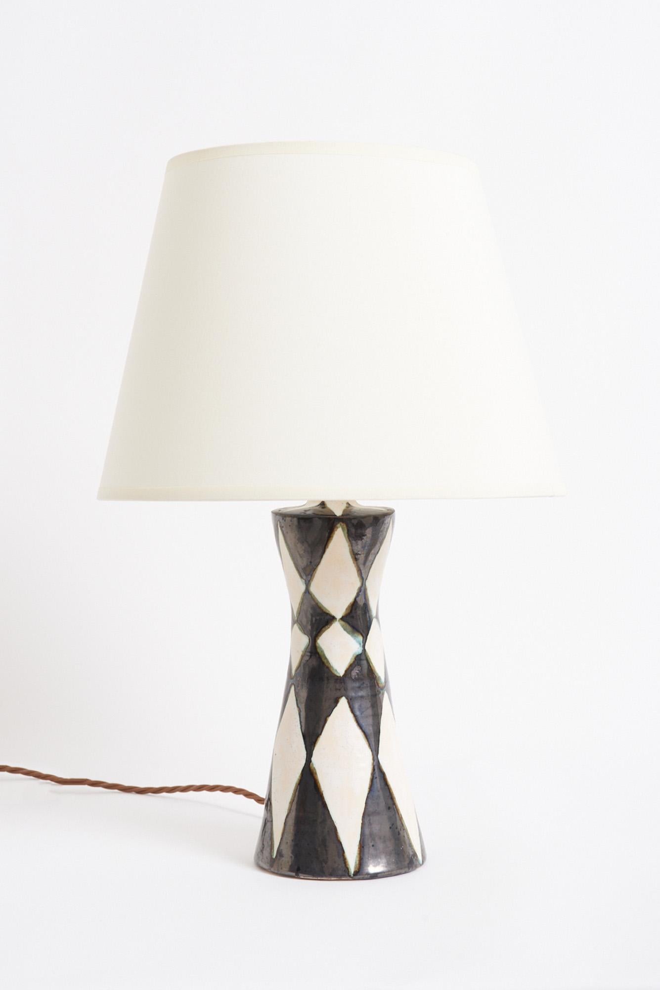 Lampe de table en céramique Harlequin
France, milieu du 20e siècle
Avec l'abat-jour : 44,5 cm de haut par 30,5 cm de diamètre
Base de la lampe uniquement : 29 cm de haut par 9 cm de diamètre