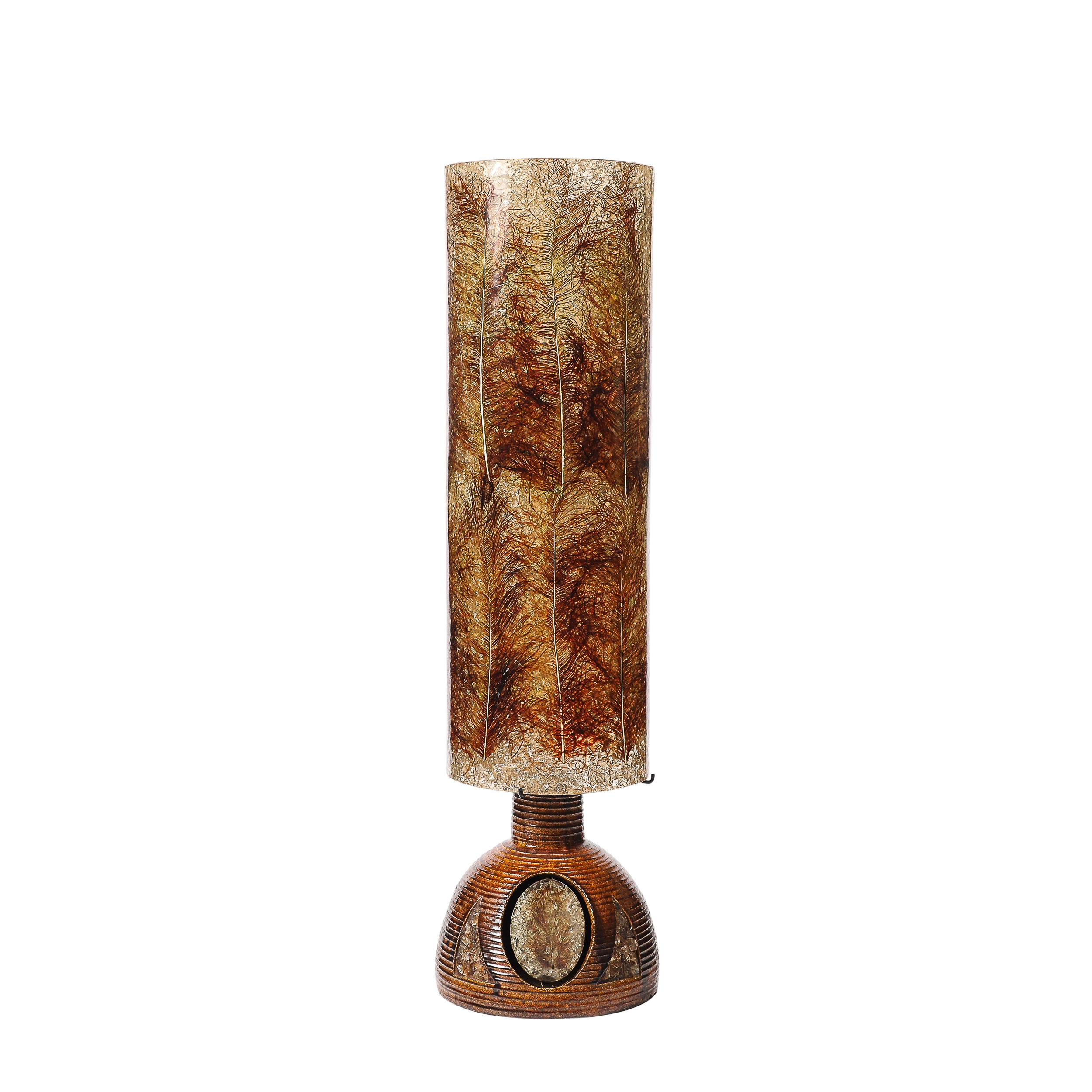 This striking Mid-Century Modernist ceramic floor/table lamp, crafted in France circa 1960, is a harmonious blend of stunningly curated natural materials and modernist design principles. The ceramic body showcases an elegant sculptural form,