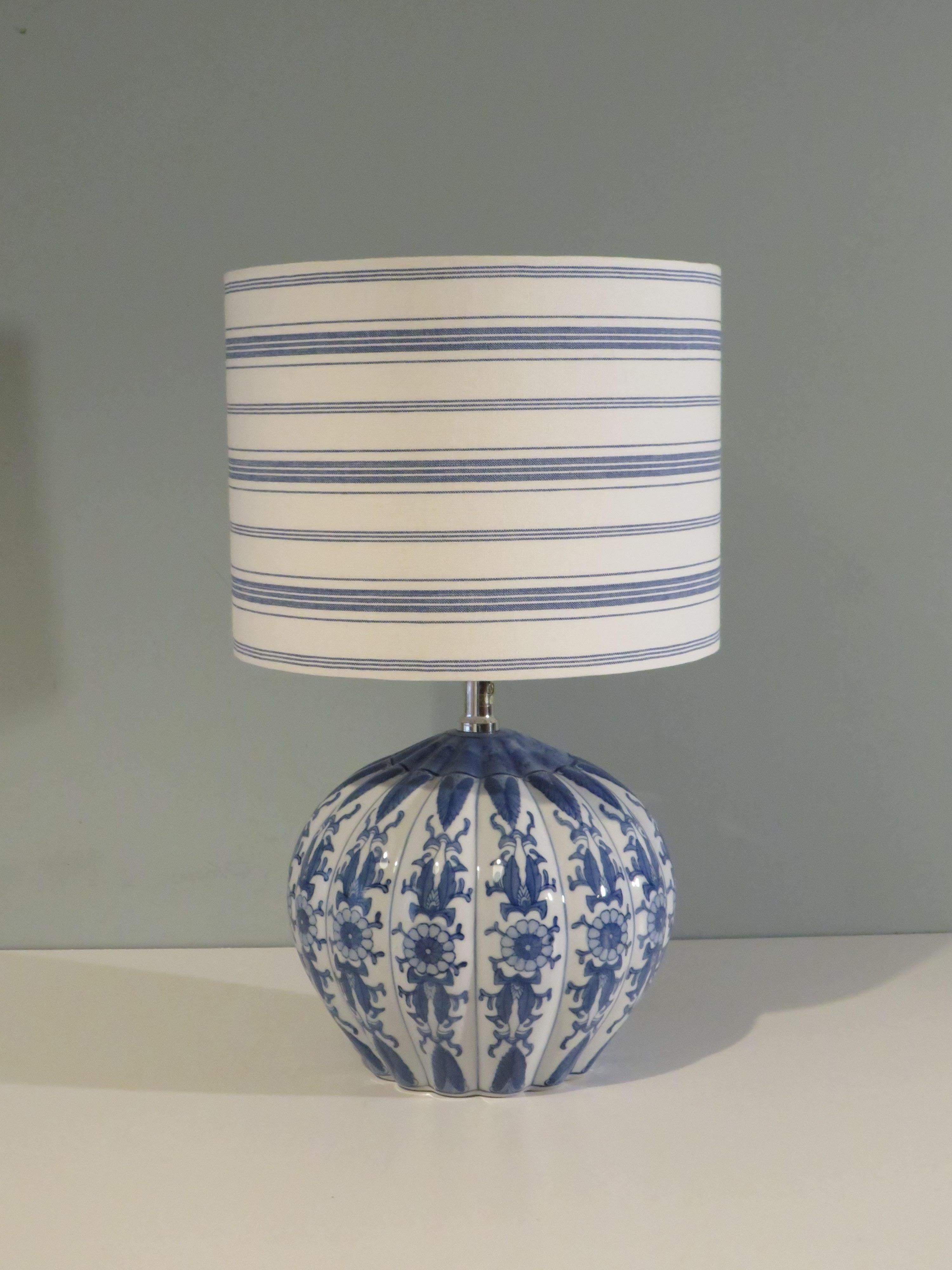 Oriental inspired blue and white glazed ribbed spherical lamp base.
With a custom handmade lampshade with linen blue and white striped fabric.
The lamp base has an E 27 fitting and can be turned on and off at the socket.
When delivered to the US, an
