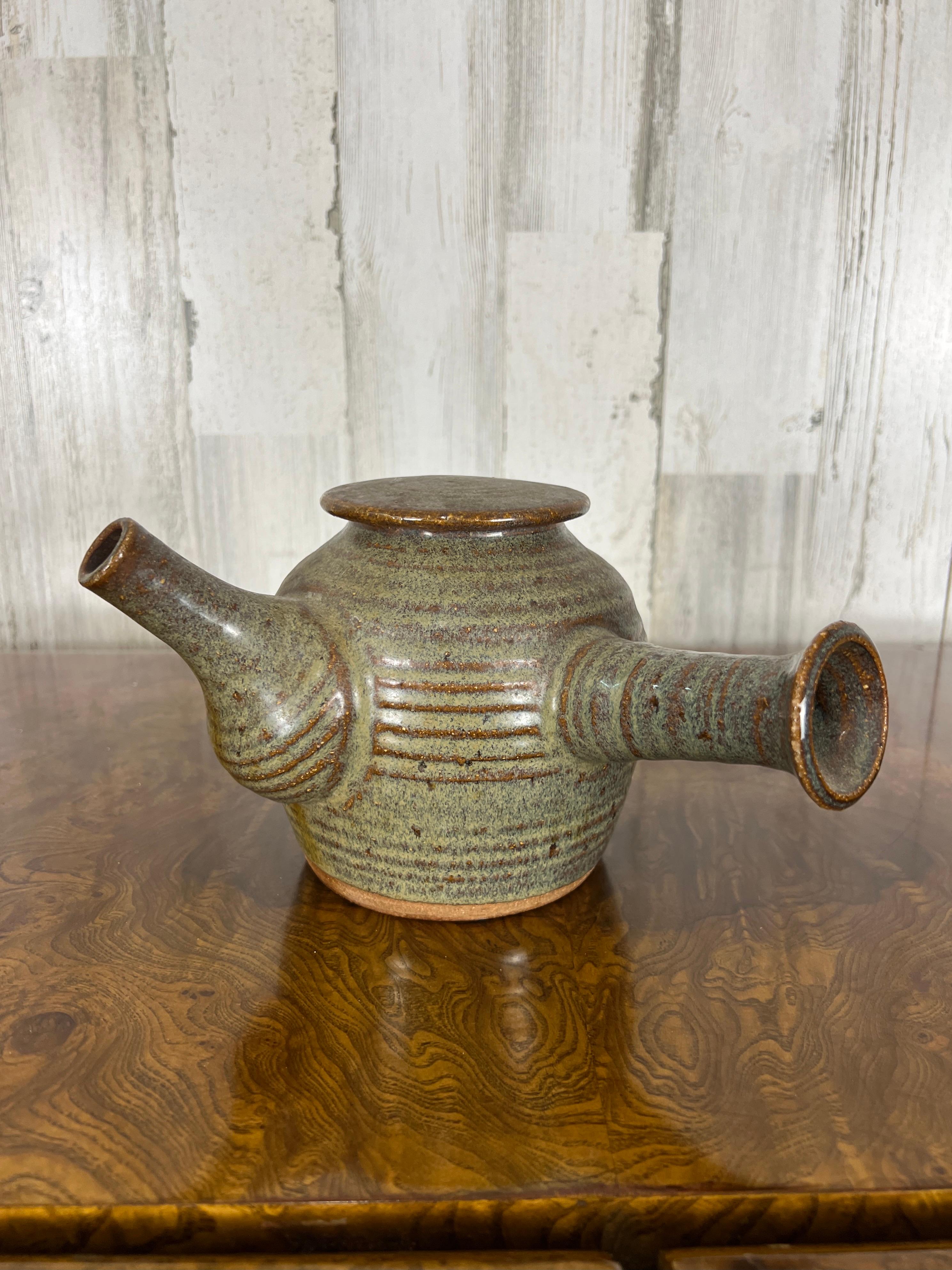 Unusual tea pot with the handle mounted on the side.