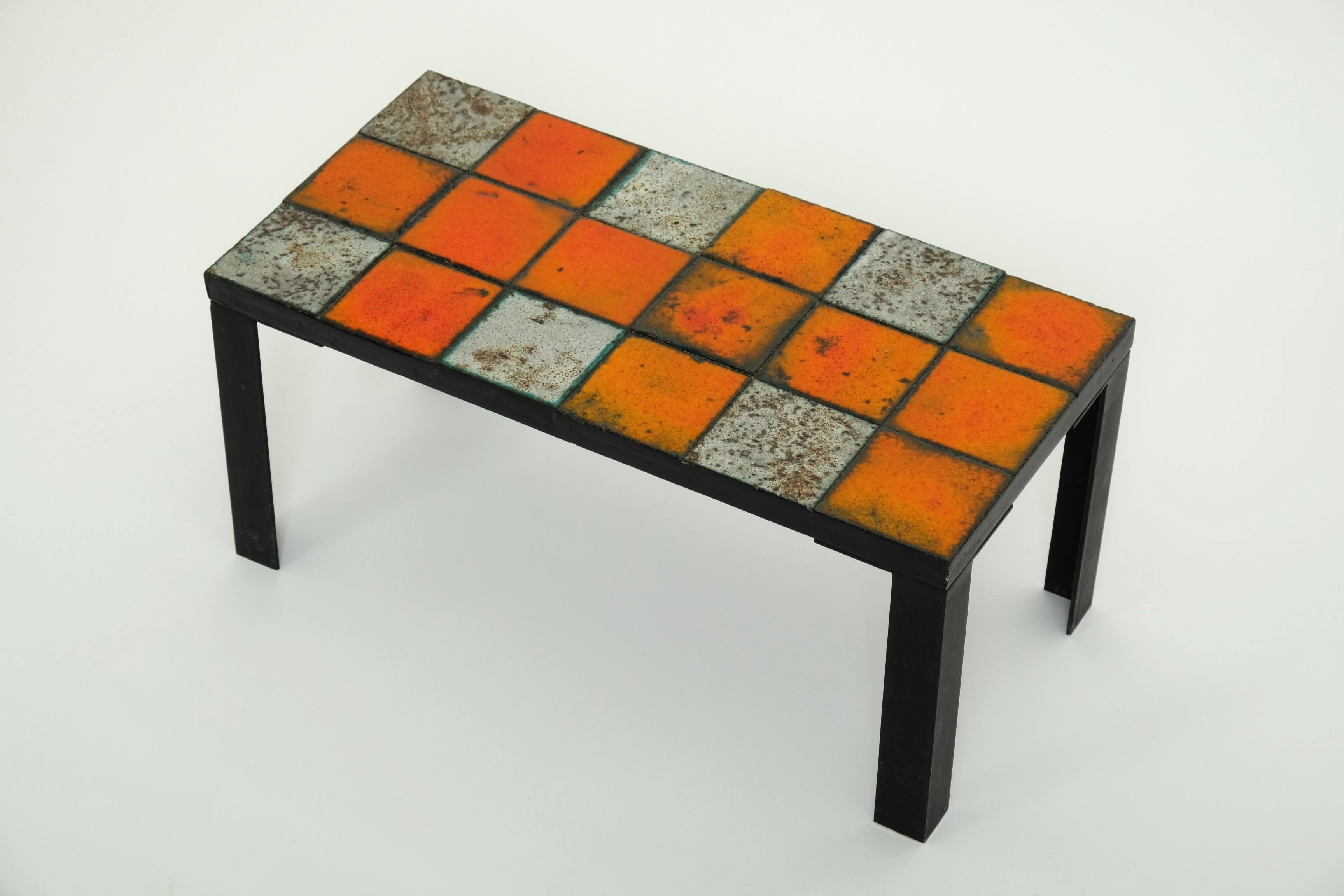 Magnifique table d'appoint en céramique des années 1960. Design/One inconnu.

Cette table unique en céramique est munie de pieds en métal de couleur noire. Le plateau de la table est une combinaison géométrique de 18 carreaux de céramique de couleur