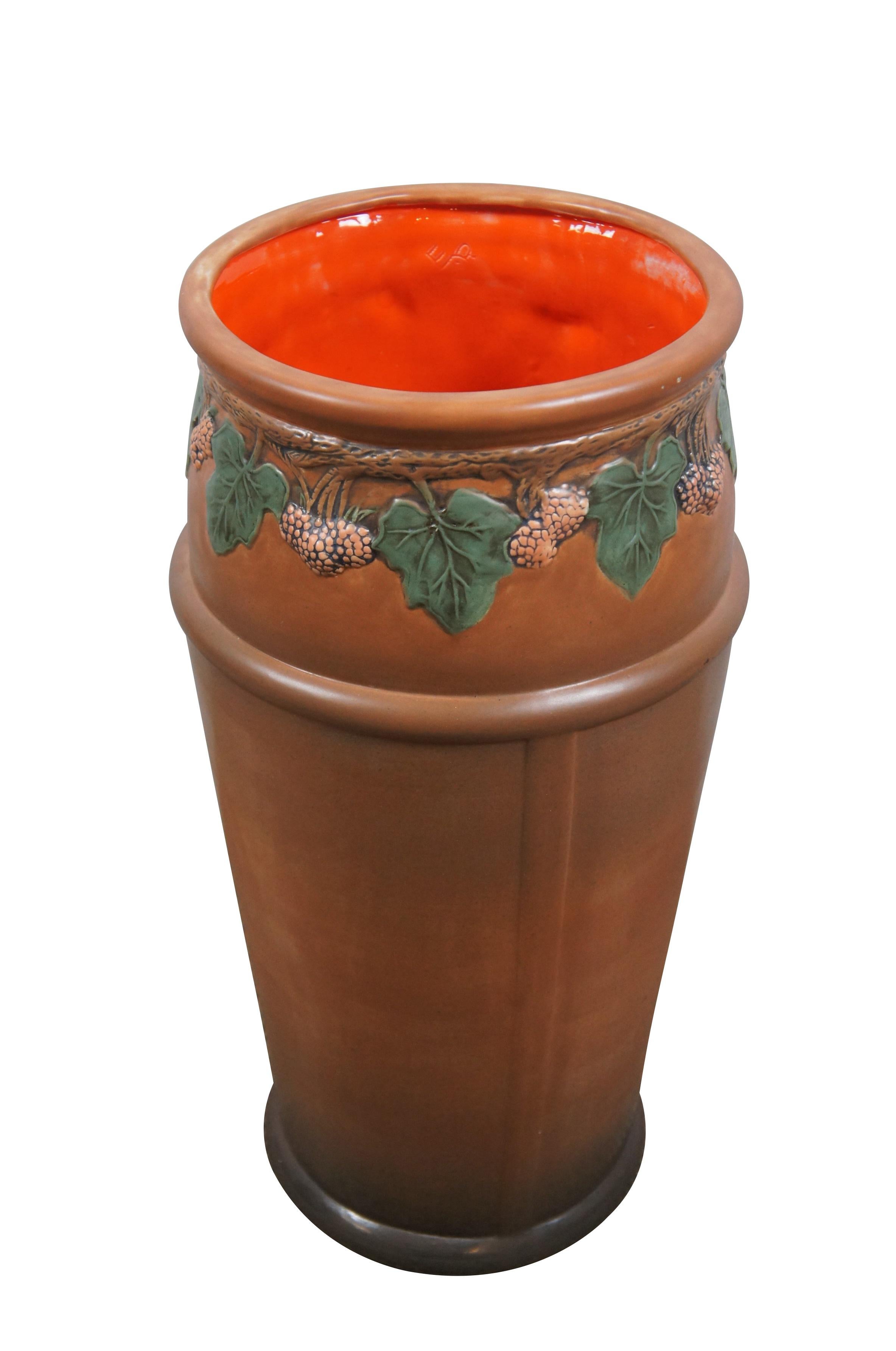 Mid 20th century ceramic umbrella / cane stand. Cylindrical body with molded straps and raspberry vine around the upper edge; brown ombre coloring with orange interior. Marked E.P and 