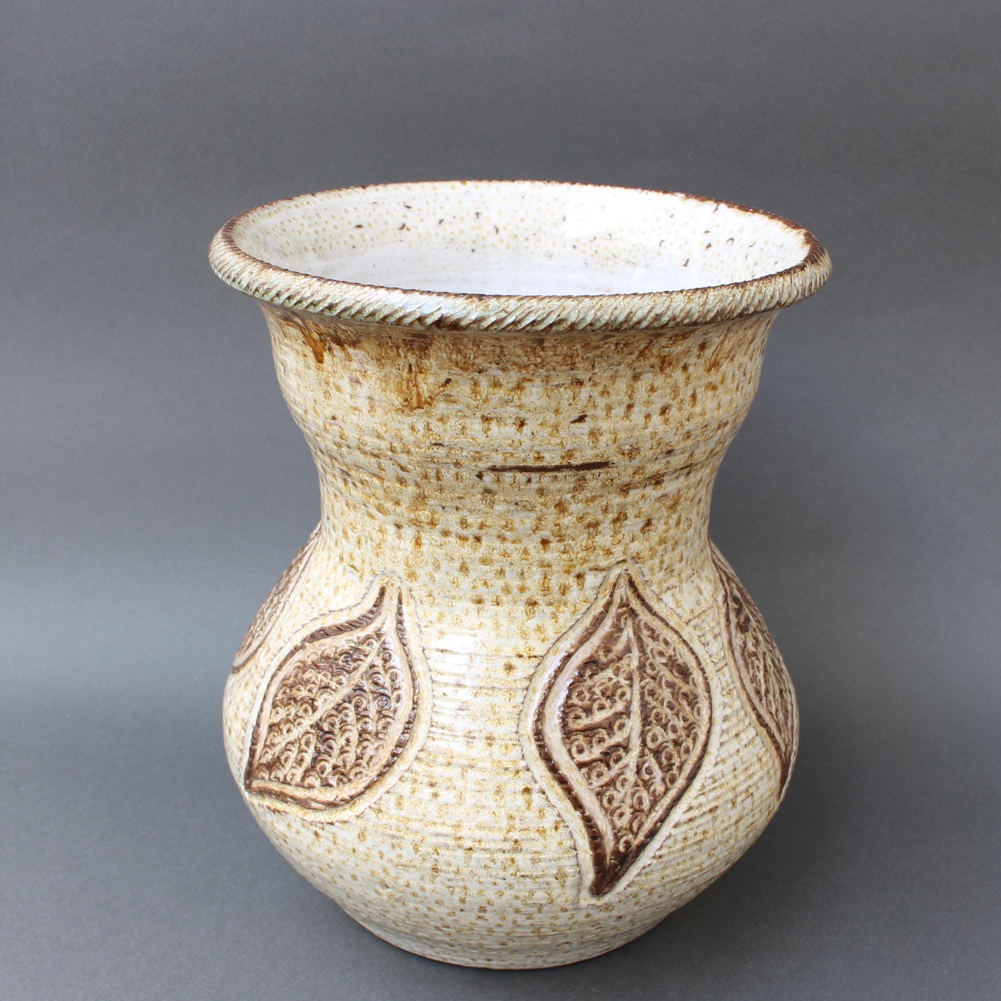 Midcentury ceramic glazed vase (circa 1960s) by Marcel Giraud, Vallauris, France. A piece with a graceful, curvy shape, wide mouth and muted chalk-coloured base with variegated glaze of brown speckles, it is Classic vintage 20th century style. This