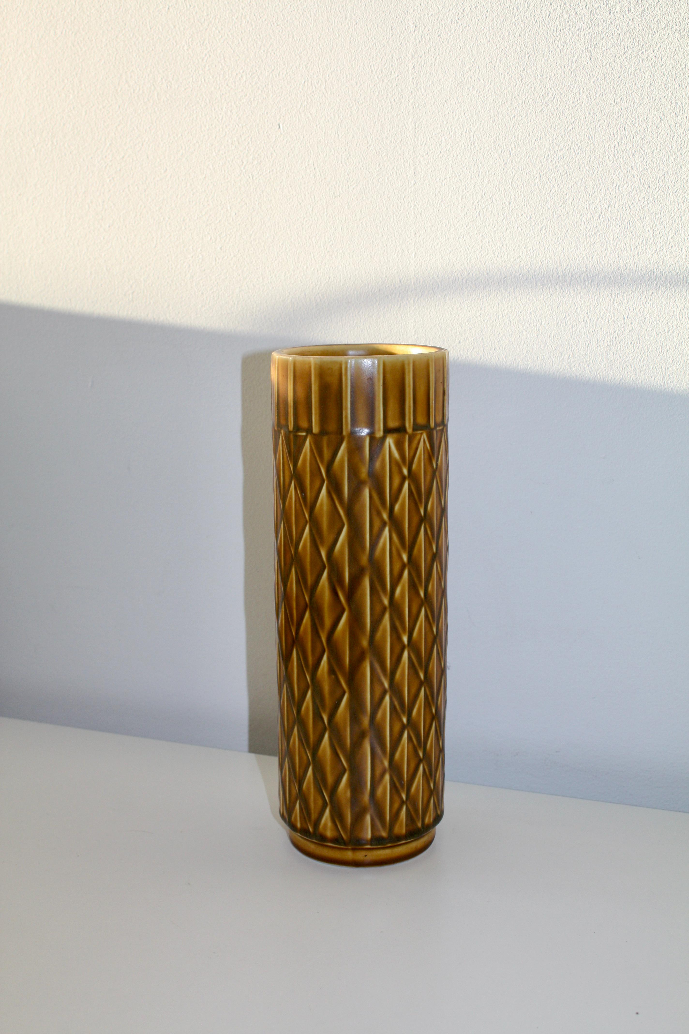 Si tratta di un vaso vintage in gres disegnato dal prestigioso e noto artista/designer Gunnar Nylund per Rörstrand.
Questo vaso cilindrico in ceramica della serie Eterna è stato realizzato negli anni '60 con un fantastico motivo geometrico e uno