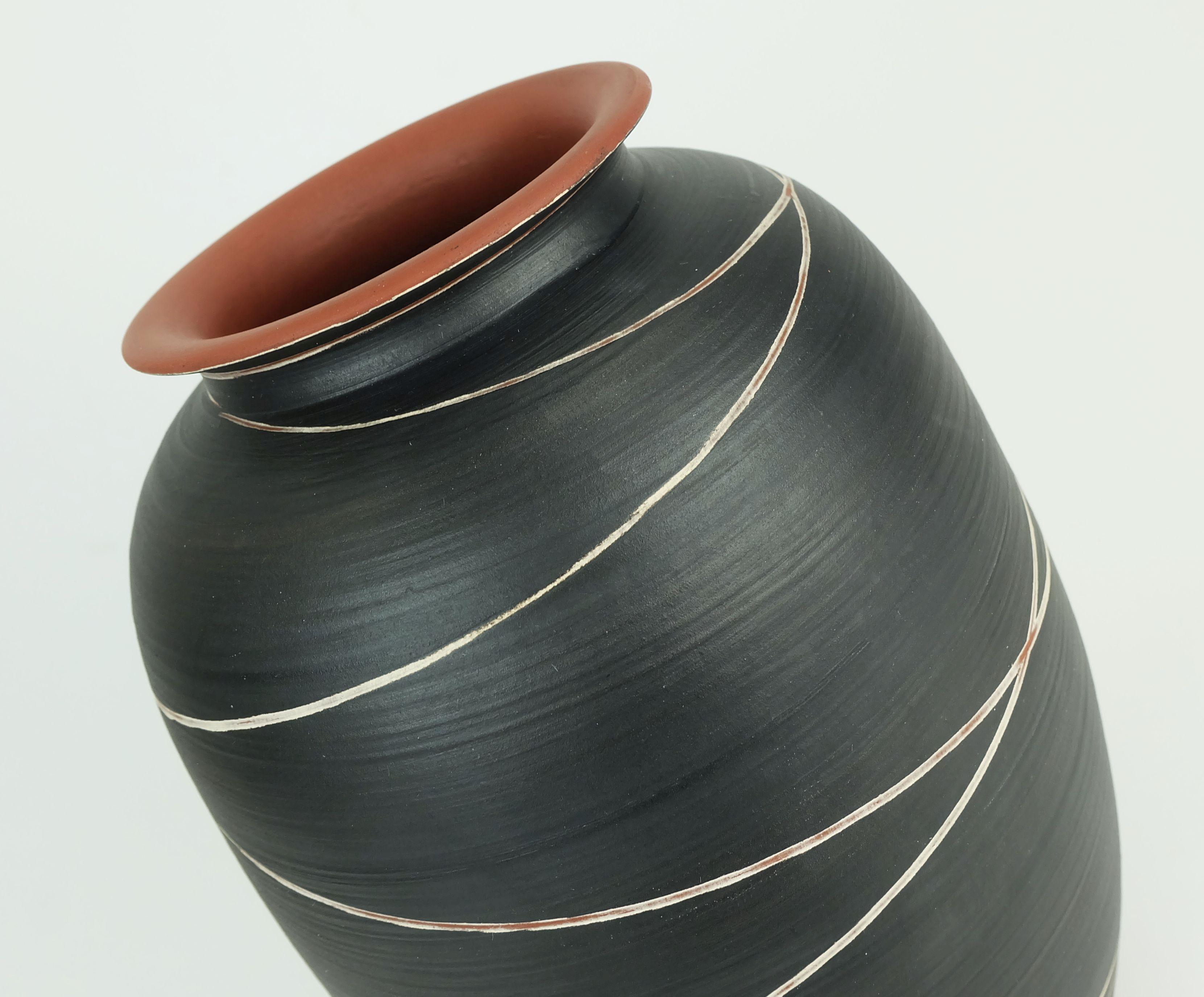 Vaso in ceramica degli anni '50 prodotto da WEKARA (Wilhelm Krumeich KG, Ransbach-Baumbach, Germania). Modello 10/30 con decoro a strisce chiare su smalto nero opaco. Smalto ruggine alla base, sul bordo e all'interno. Marcato sul fondo WEKARA