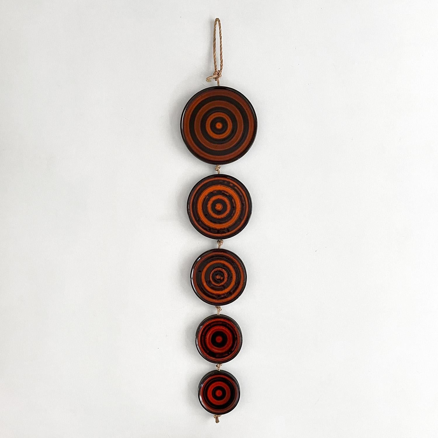 Ceramic disc wall sculpture
Germany, circa 1960’s
Five unique ceramic discs with concentric rings
Bold and contrasting color palette ranging from deep reds to burnt orange against stark black
Original rope cording with light surface markings
Patina