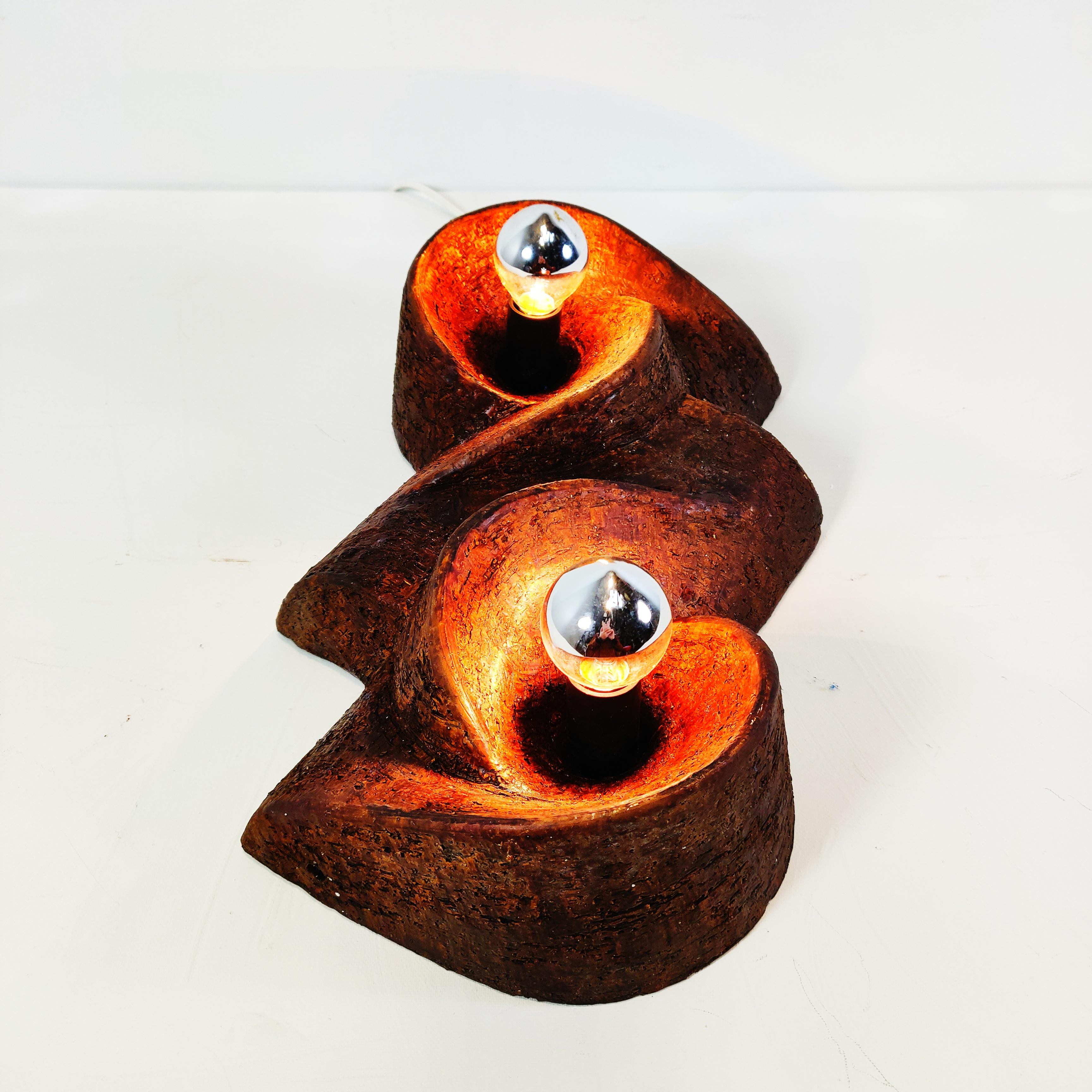 This mid century ceramic wall lamp in a abstract organic fat lava design is made in the 60s. Its wonderful to see the light and shadow come together.
Its also possible to use the lamp as a table lamp

The lamp needs two E14 lightbulbs
