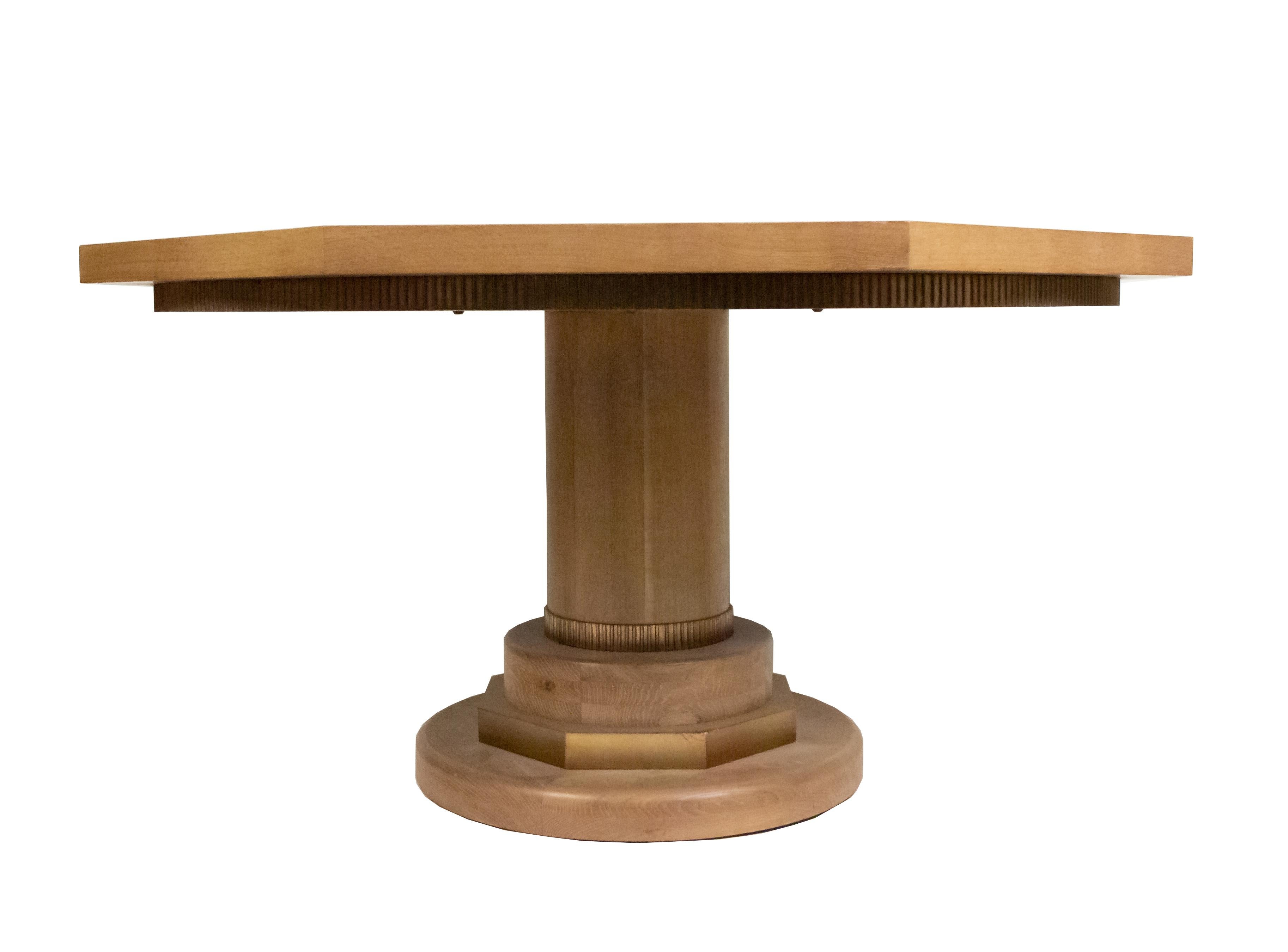Midcentury cerused oak pedestal base center / dining table having a round octagonal top with a fluted edge and dark wood and metallic insets.