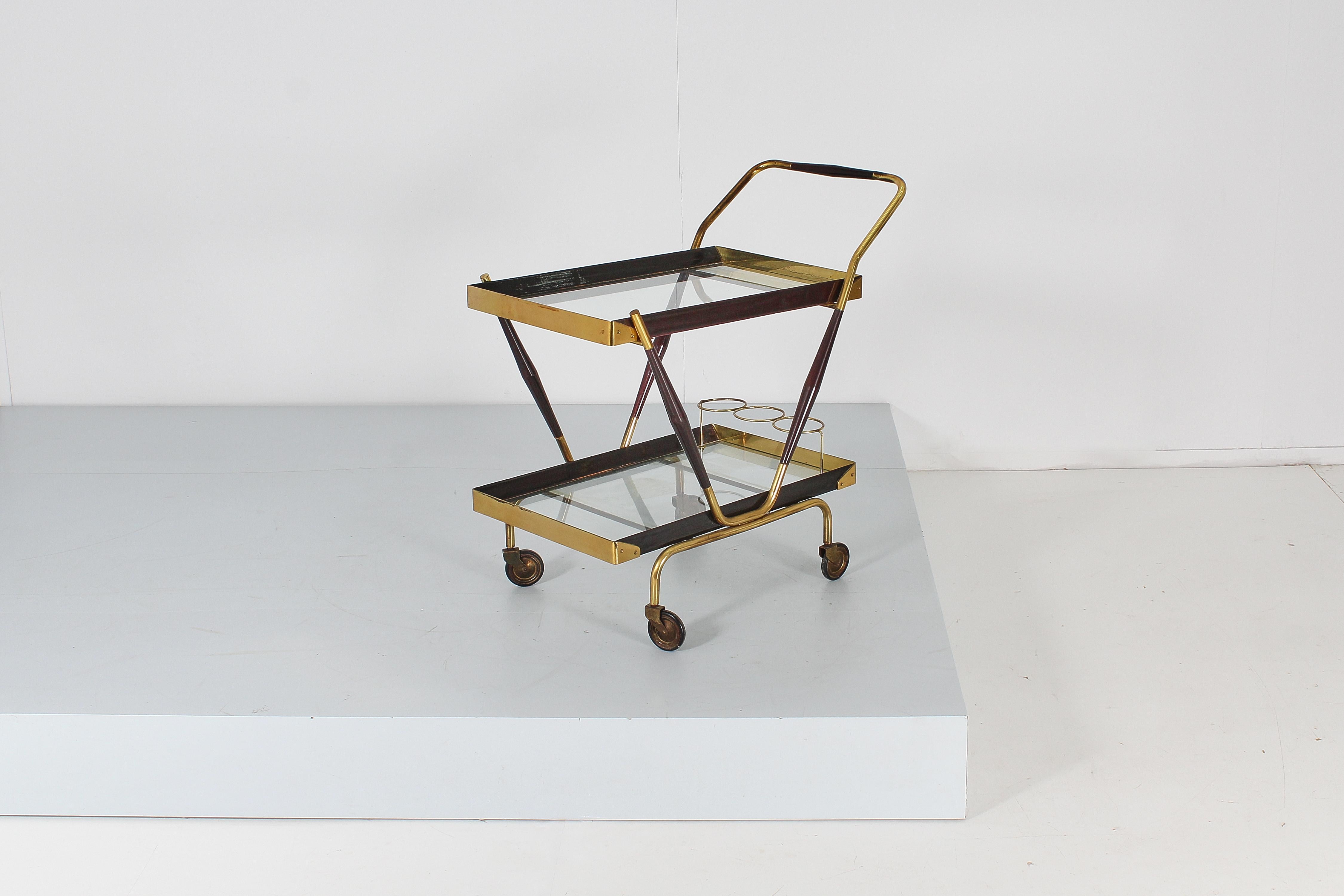 Very elegant two-level bar cart, with geometric lines in gilded brass and dark wood with three circular slots for bottles. Attributable to Cesare Lacca, Italian production in the 60s.
Wear consistent with age and use.
