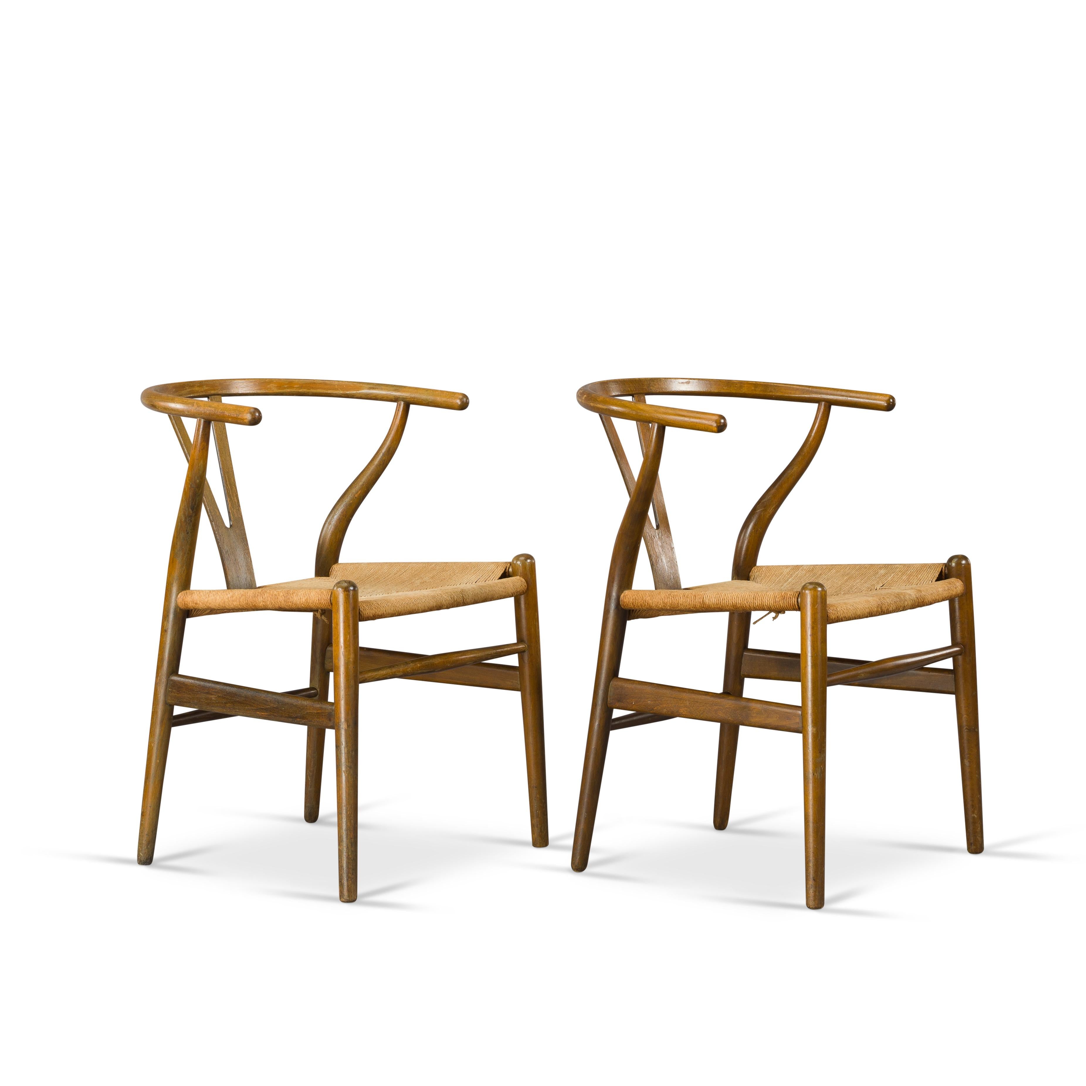 These two CH24 wishbone armchairs are designed by Hans J. Wegner. And produced in the 1950s by Carl Hansen & Søn in Denmark. The frame is made from oak. These chairs were painted originally and time has worn off the paint in a nice patina. The
