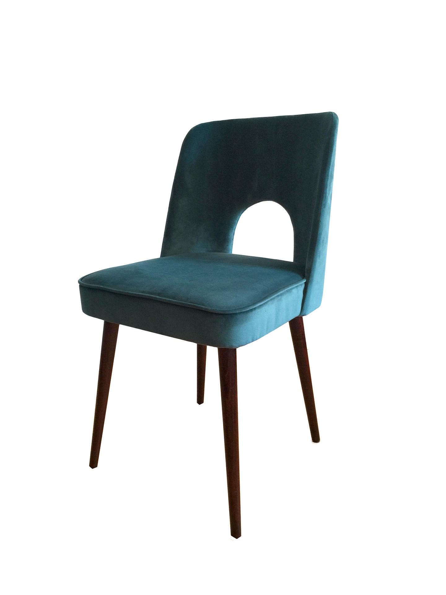 This set of two dining chairs with a modernist silhouette was designed circa 1962 and manufactured by Slupskie Fabryki Mebli in Poland. The structure is made of plywood and beech. The upholstery is made of high-quality fabric in a deep sea-blue