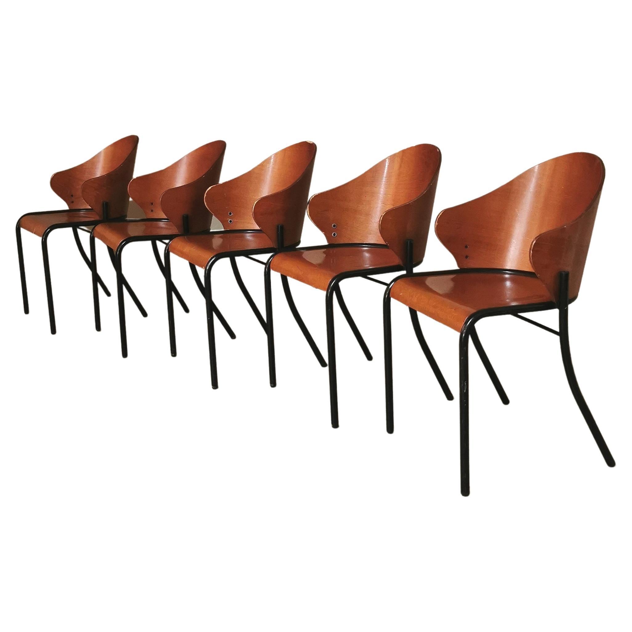 Set of 9 dining chairs in the style of Philippe Starck with unusual shapes produced in Italy in the 1960s. The chairs have a black enamelled tubular metal frame and back legs of a particular curved shape with seat and back in curved wood.

