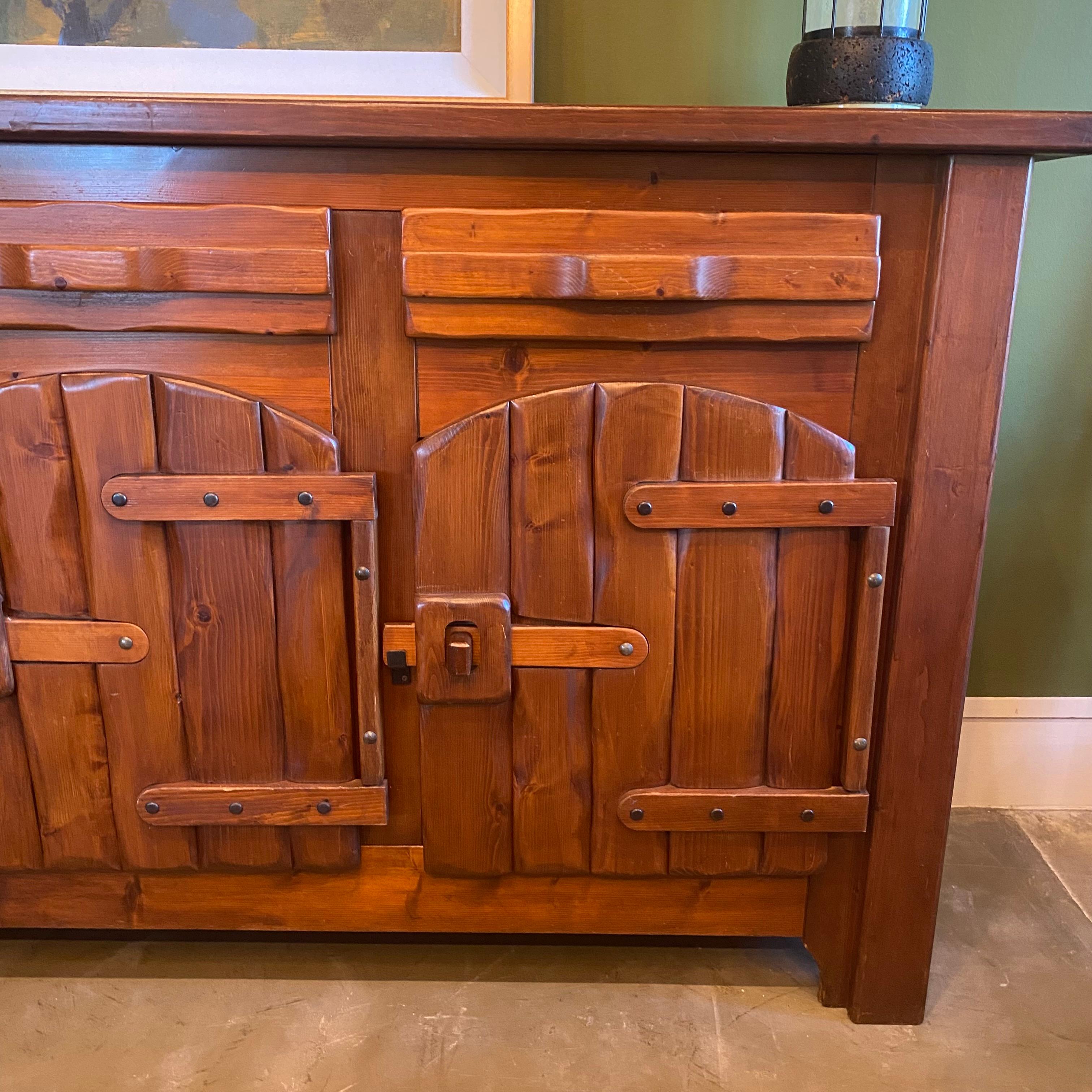 Solid elm Brutalist sideboard in the style typical of mid-century French Alps mountain homes. Great scale and well crafted with decorative doors, drawers and steel latches. Finish has been professionally touched up and the piece presents