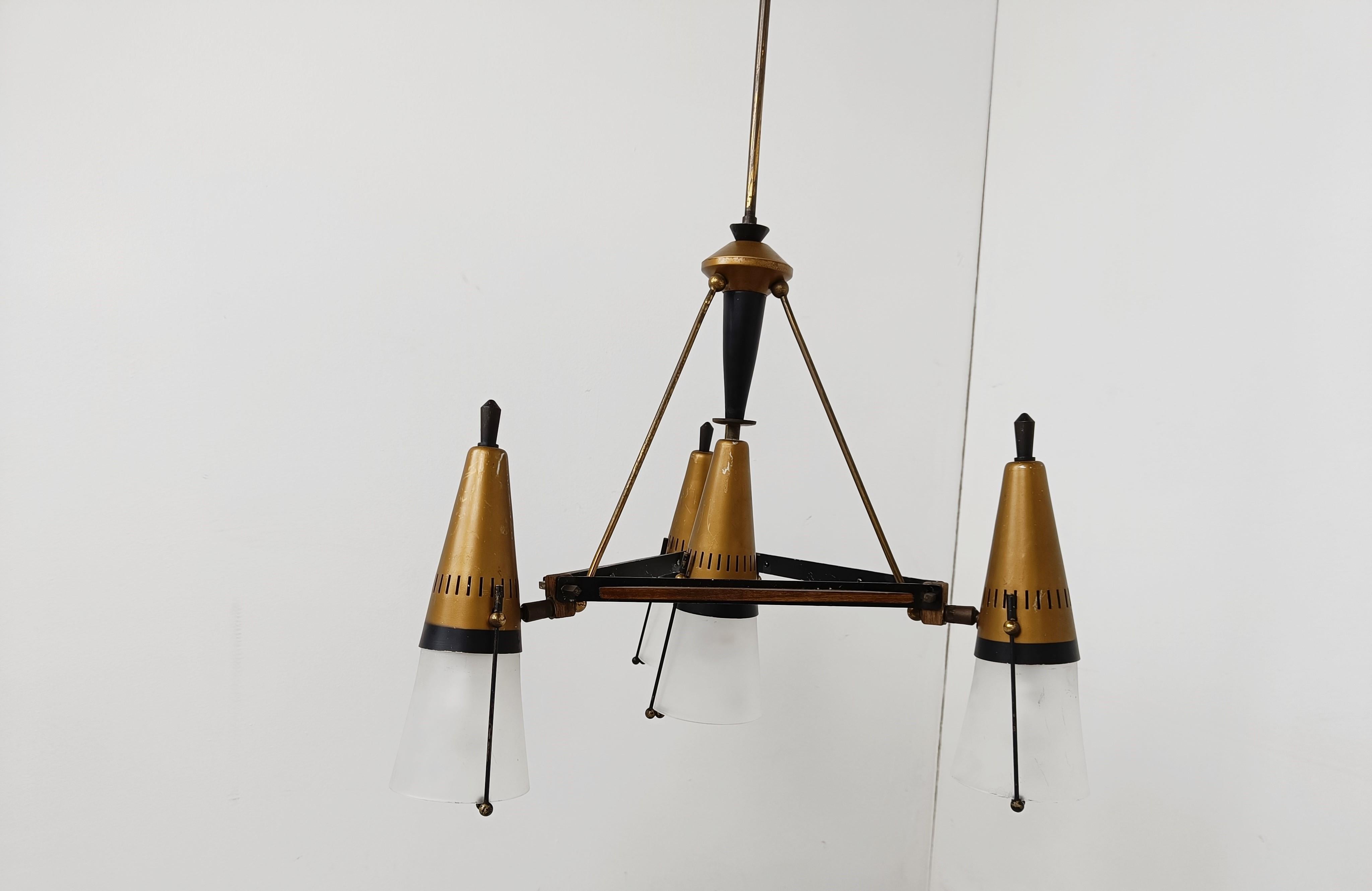 Mid century cone shaped chandelier by Oscar Torlasco. 

The chandelier has a triangular brass and wooden frame with brass cone shaped shade holders and matte white glasses.

Beautiful mid century design with the right patina.

1950s - Italy

Tested