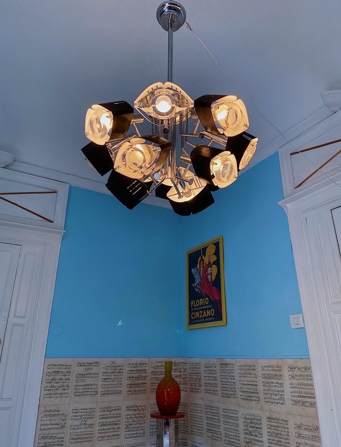 Super rare ceiling light designed by Oscar Torlasco. Made in Italy in the 1970s. 12 light bulbs. The glass lenses are in Murano glas. Each lentic glass are set in a metal structure with a mouth shape. 
Torlascos eclectic designs ranged in style
