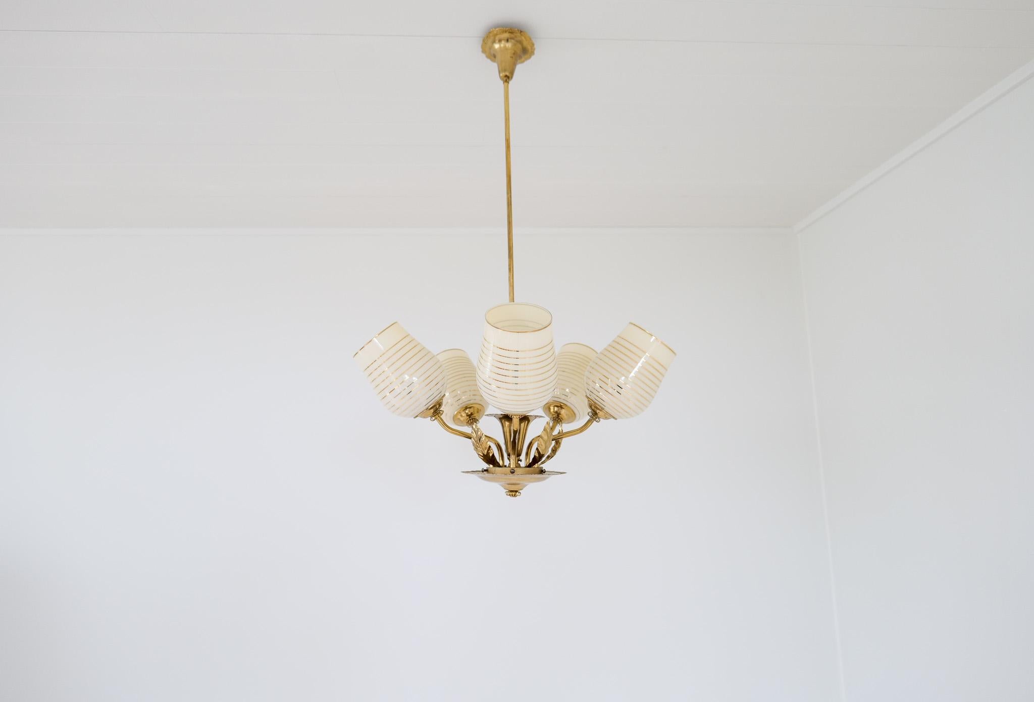 A 1950s Finnish design ceiling lamp with five light sources. The lamp is stamped Sario and sold at the Stockmann department store. The iconic Stockmann department store in Helsinki sold all lamp manufacturers' lamps back then including Orno, Taito,