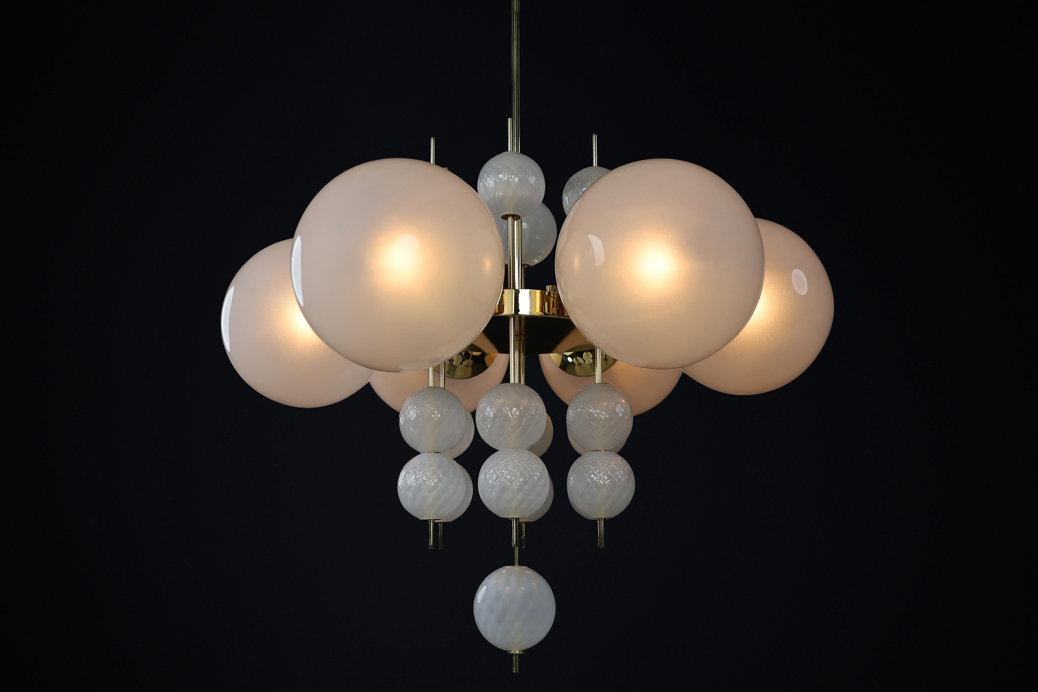 Mid-Century Chandelier with Brass Fixture and Hand-Blown Pearl-White Glass Globes by Preciosa, Czechia, 1960

This stunning Mid-Century chandelier features a brass fixture designed and produced by the renowned Preciosa Factory in Czechia. It