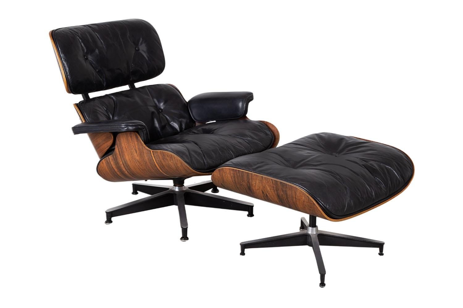 Iconic vintage mid-century Eames rosewood lounge chair and ottoman, by Charles & Ray Eames for Herman Miller 1964 to 1978. Features a beautiful sculpted molded rosewood frame and black leather cushions, creating a stunning profile, originally goose