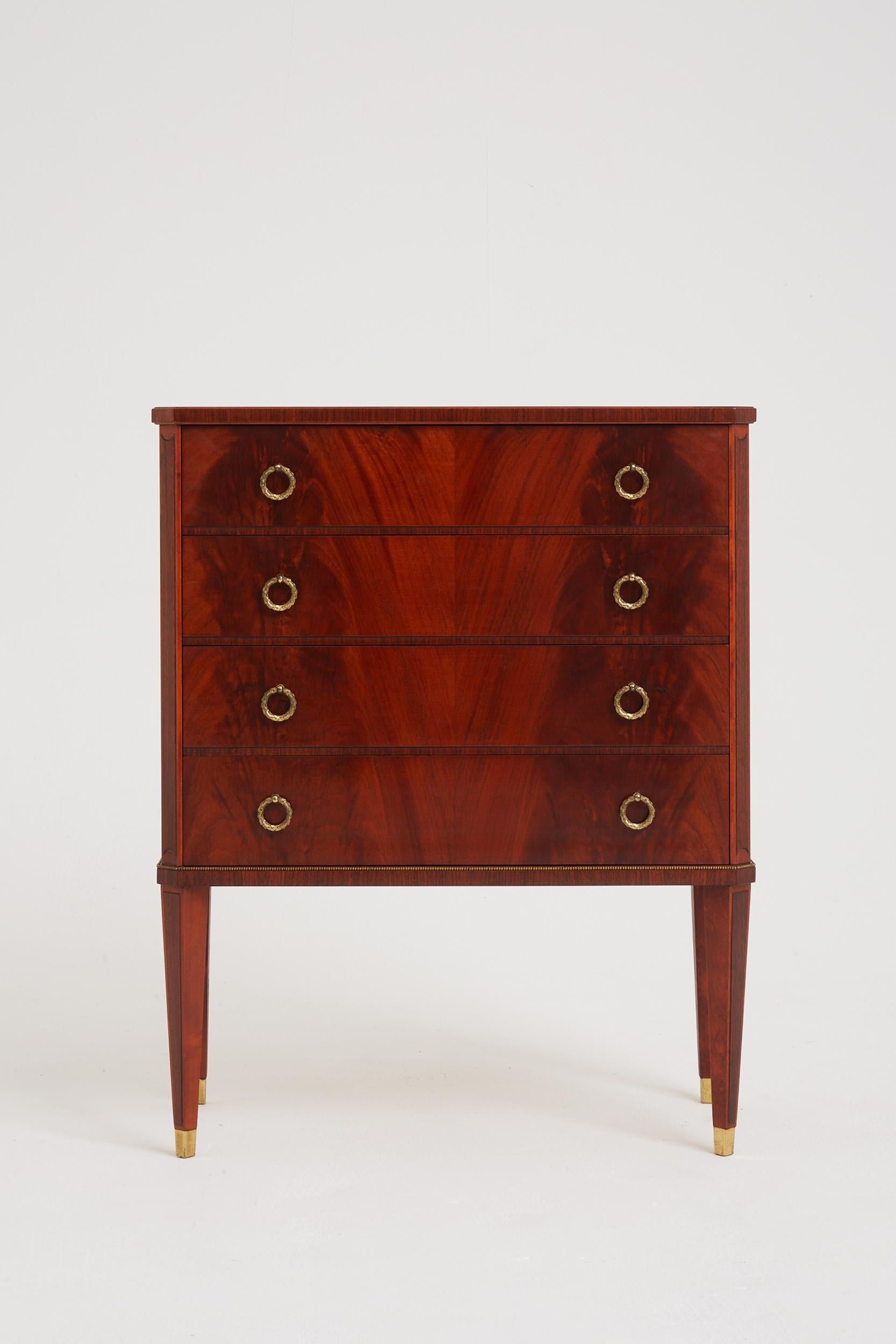 A flamed mahogany and brass chest of drawers
Sweden, mid 20th Century
82 cm high by 66.5 cm wide by 34.5 cm depth