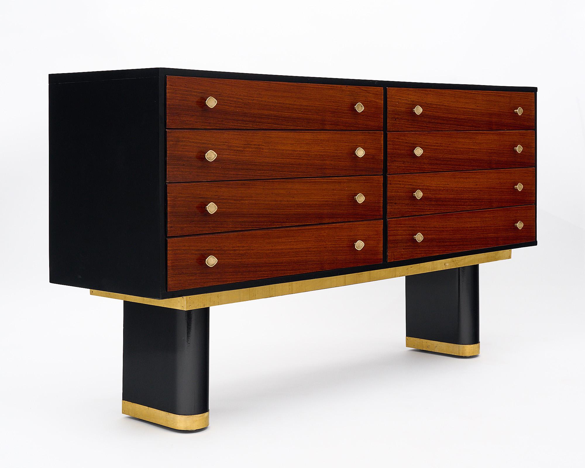 Chest of drawers, French, in the manner of Jean-Charles Moreux. This architectural chest features eight dovetailed drawers with their original bronze pulls and sits on two wooden oblong legs that have been ebonized and trimmed in brass. The sides