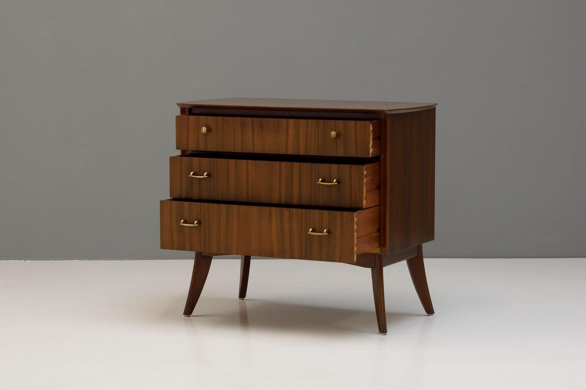 Small three drawer chest of drawers in teak and walnut by Morris of Glasgow. Original handles, the chest has been cleaned and polished. Some signs of age remain as shown in the images.
H 80cm x W 91cm x D 50cm