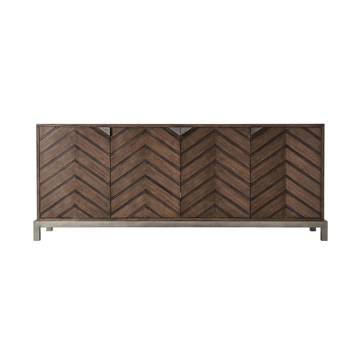 Mid-century Chevron sideboard in our Charteris finish, with a rectangular quartered oak centered top, four chevron pattern relief paneled doors, and triangular hammered metal handles on a matte tungsten finish base. Fitted with three interior