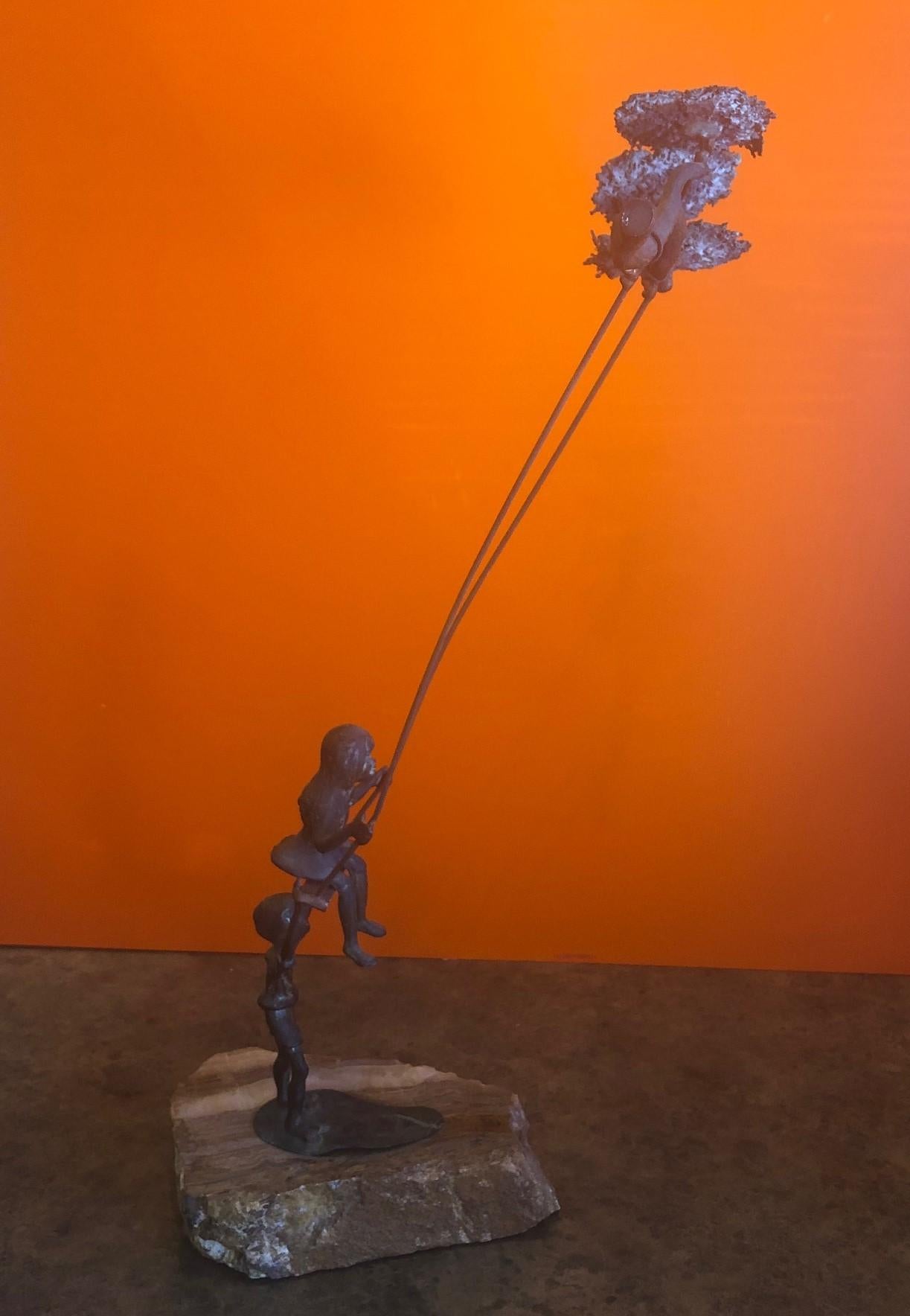 boy pushing girl on swing statue