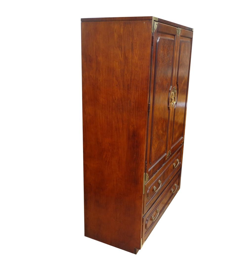 Midcentury Chin Hua Campaign Armoire by Bernhardt
 
 
 This armoire features two cabinet doors with burl veneer panels and brass tone hardware opening to four storage compartments and a drawer over two additional drawers with brass tone handles