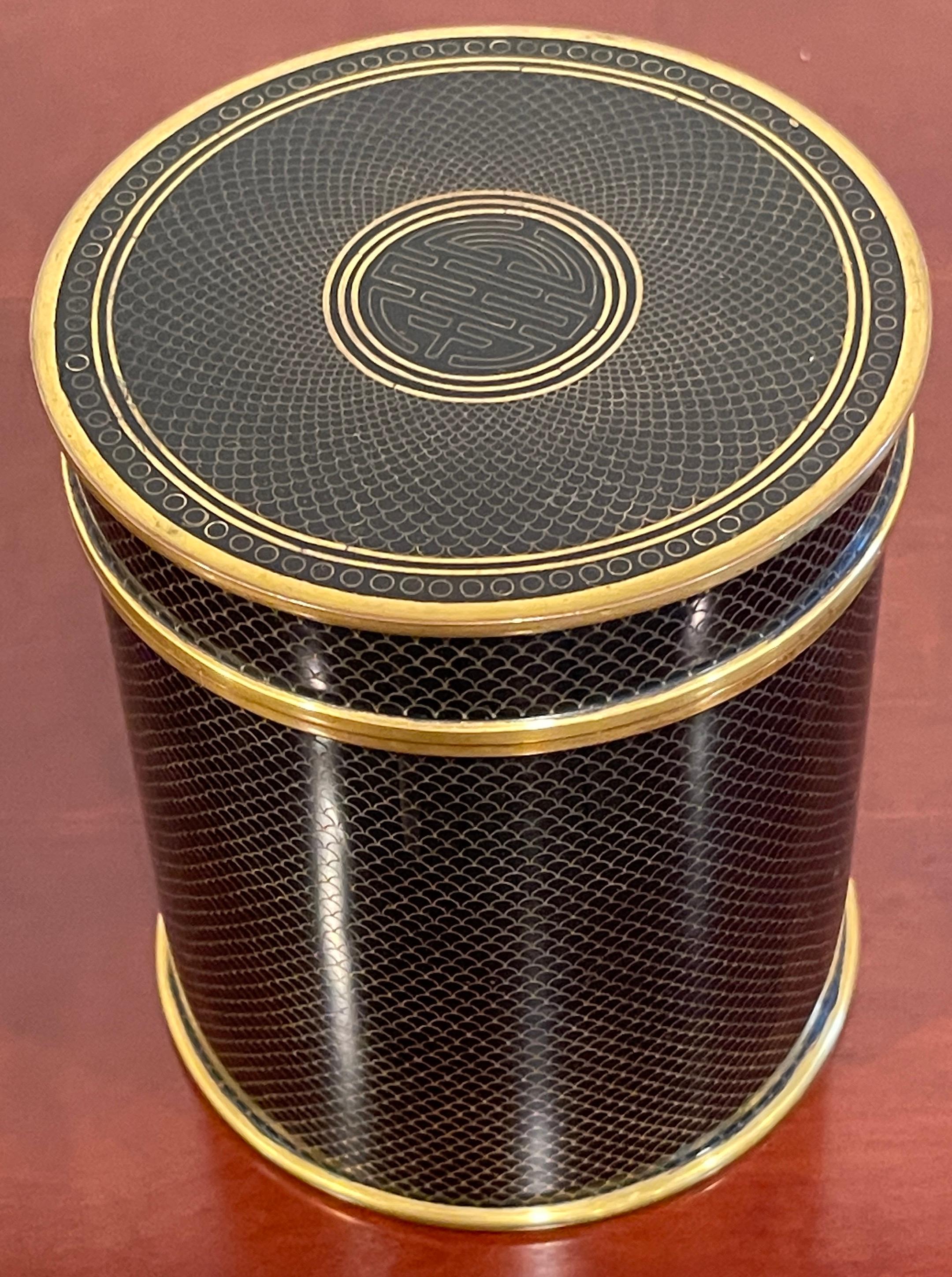 Mid-Century Chinese black & gold cloisonné 'good luck' circular table box.
The tall circular box of exceptional quality, The conforming removable lid enameled with the Chinese character for 'Happiness' A stately piece, its an unusual example in