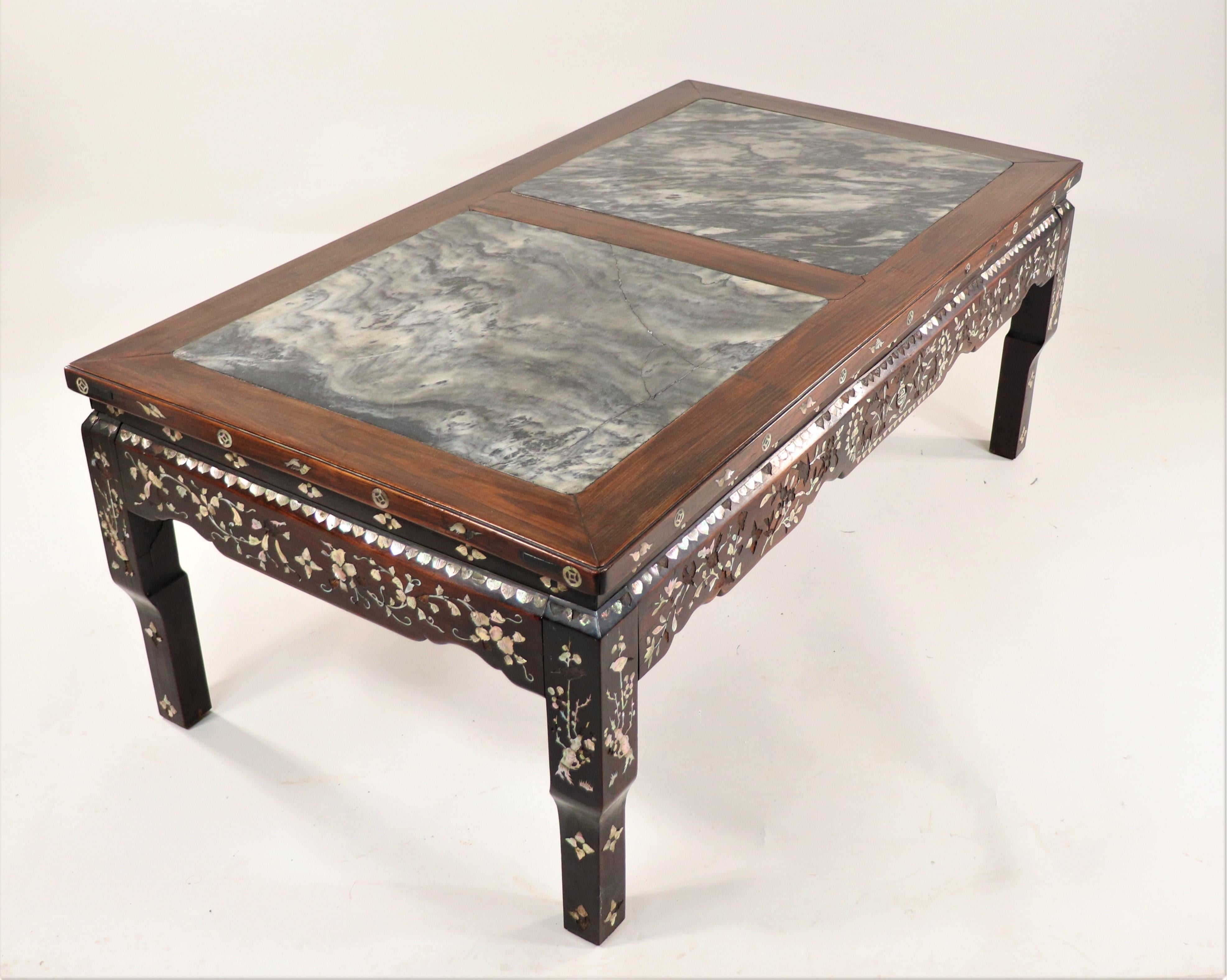 This beautifully hand-carved coffee table features a marble inset top with mother-of-pearl inlay decoration. These tables are popular due to their beautiful aesthetic, craftsmanship, and overall attention to detail. Many coffee tables were
