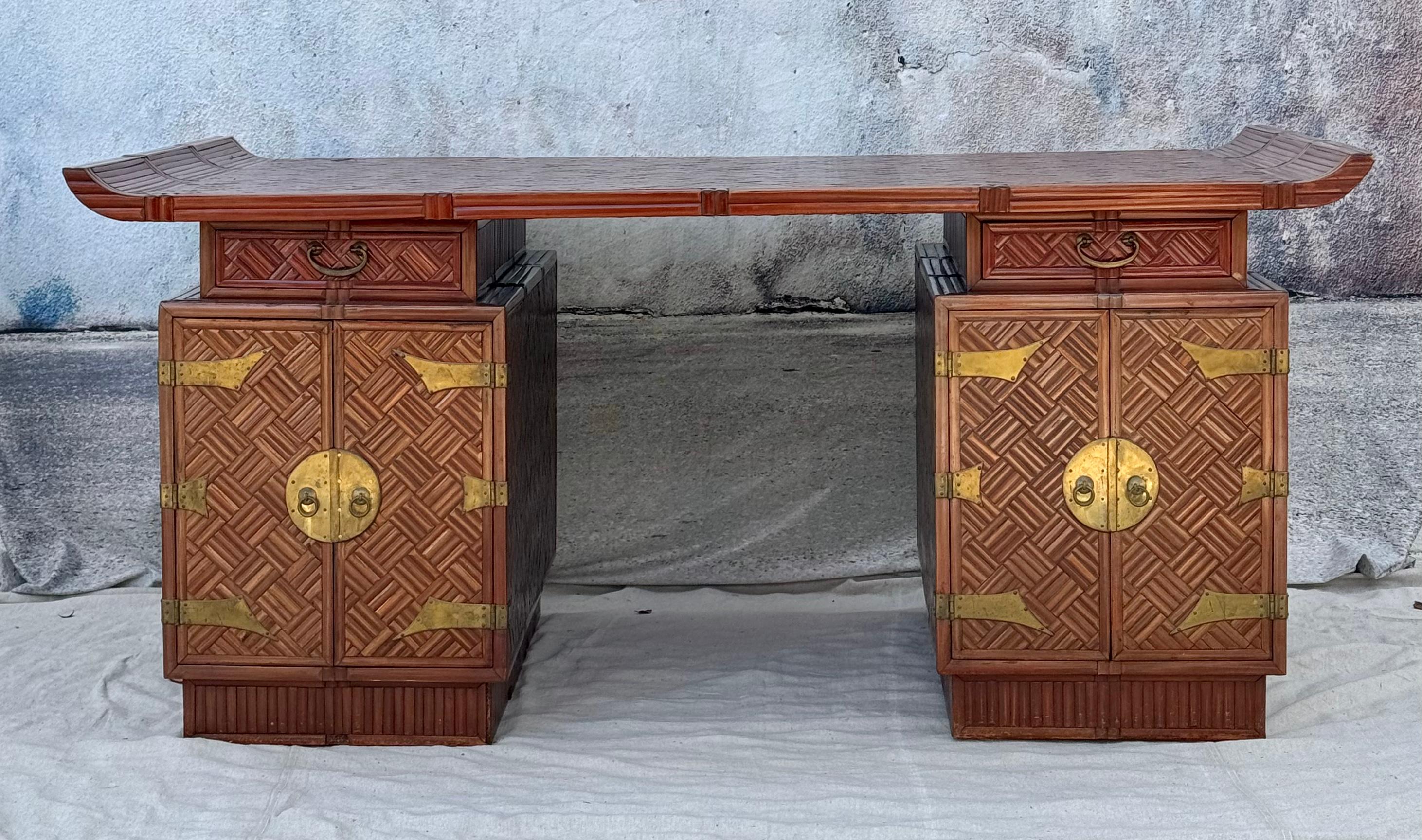 A rare and unique Mid Century Chinese Export Partners Desk, Applied Bamboo over Hardwood. A partner's desk describes a desk in which two people can work opposite each other. This desk features a bamboo top with Pagoda style ends adding a distinctive