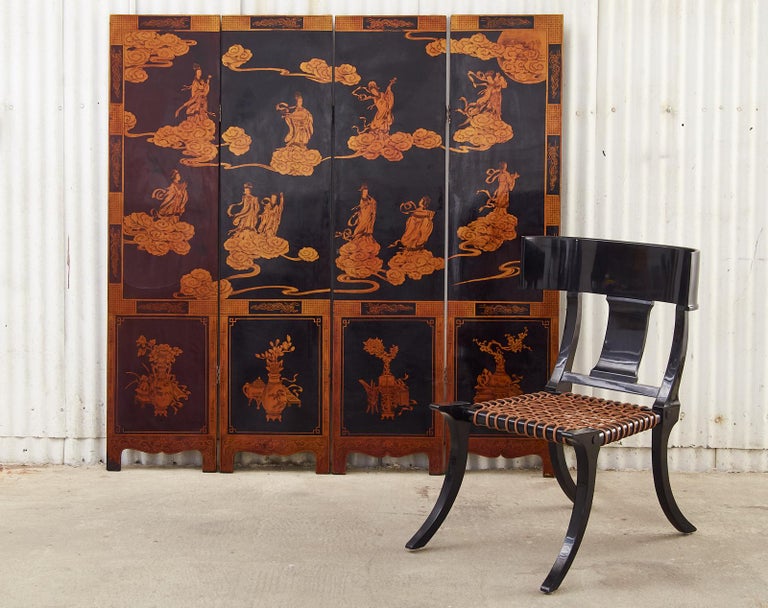 Heavenly Mid-Century Modern period Chinese export lacquered coromandel screen featuring four panels depicting celestial beauties in the sky with decorative ruyi clouds and moon. Solid wood panels lacquered with a black ground decorated with gilt