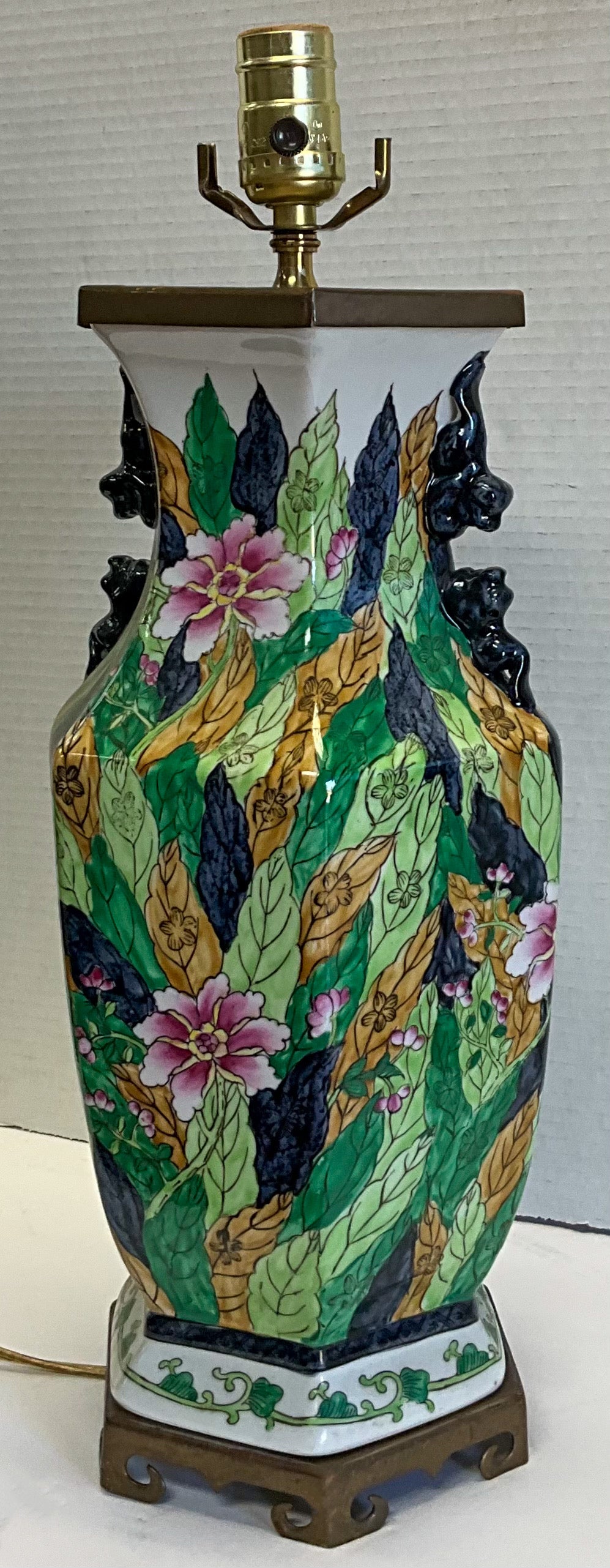 This is a Chinese Export style porcelain table lamp in the vibrant tobacco leaf pattern. The wiring is new, and it is mounted to a brass base. It is unmarked.
