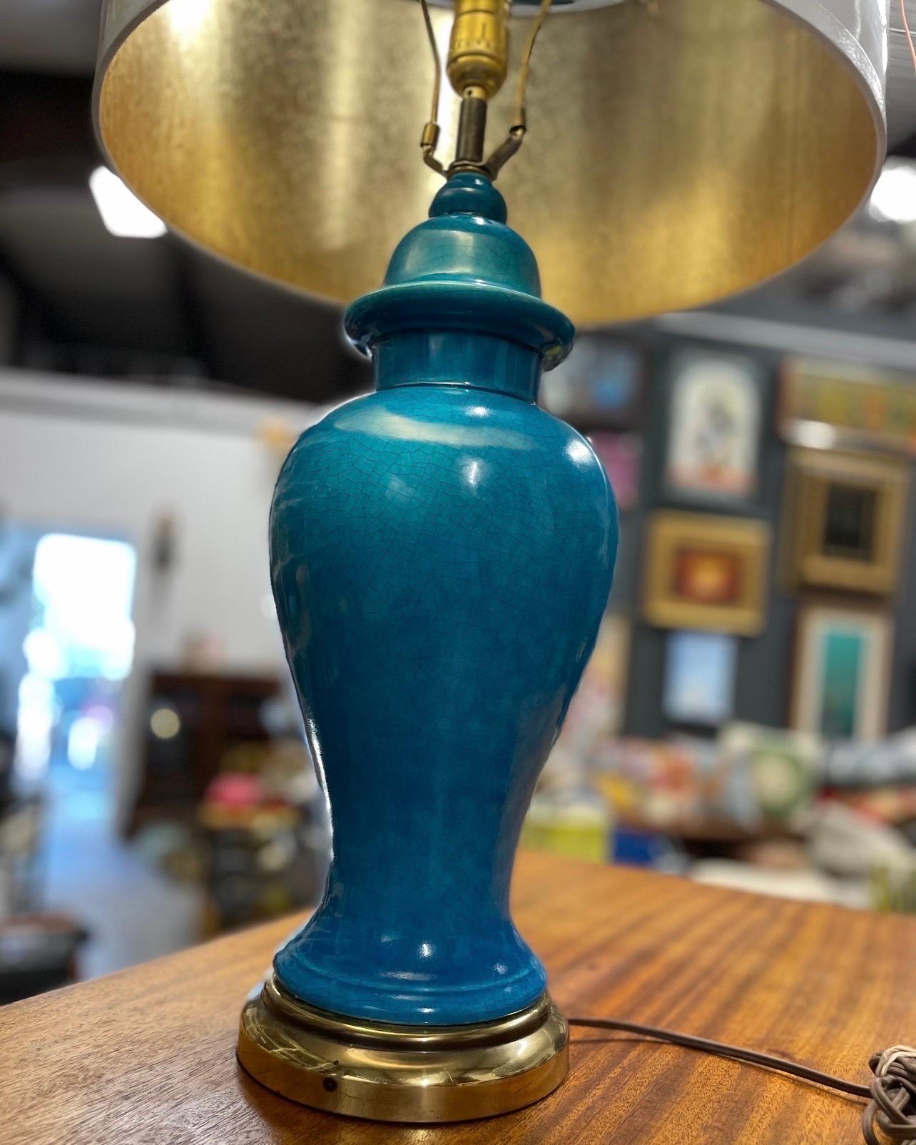 A gorgeous Chinese style ginger jar glazed blue ceramic table lamps with brass base, circa 1970. Good condition with age appropriate wear.  White drum shade with a glossy finish compliments the crackle finish on the lamp.

27 1/2” h w shade
16 inch