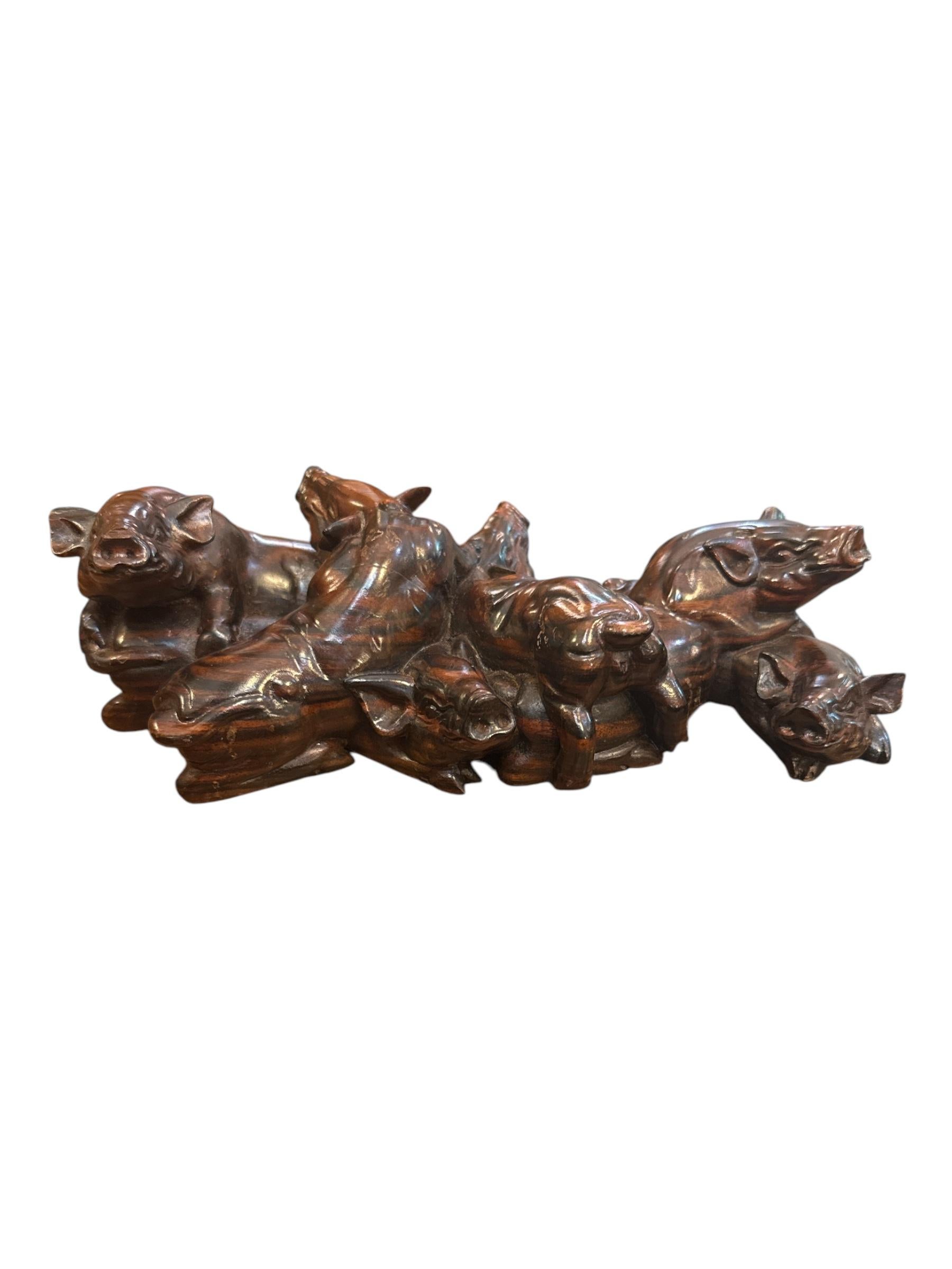 Cette statue de cochon en bois de fer chinois du milieu du siècle, sculptée à la main, est une œuvre d'art remarquable et unique qui reflète magnifiquement l'artisanat traditionnel chinois. Sculptée de manière experte dans un bois de fer dense et