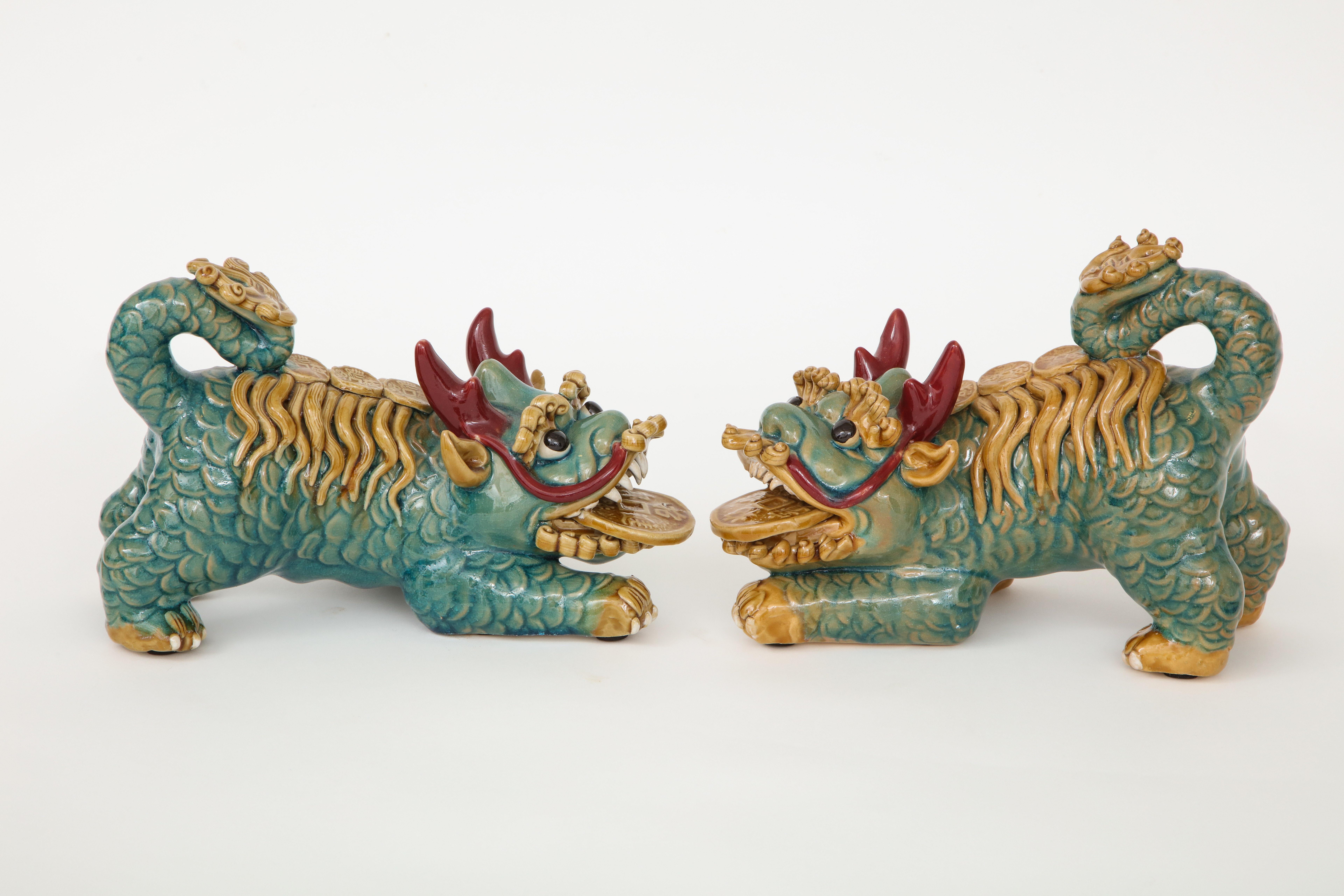 Pair of polychrome highly decorated foo dogs with hand applied details.