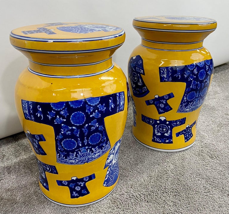 An exquisite pair of mid-century Chinese porcelain garden or table stools. The stools can also be used as pedestals. Each pedestal is finely hand-painted in yellow an d featuring Chinese traditional robes in blue and white around the stool and