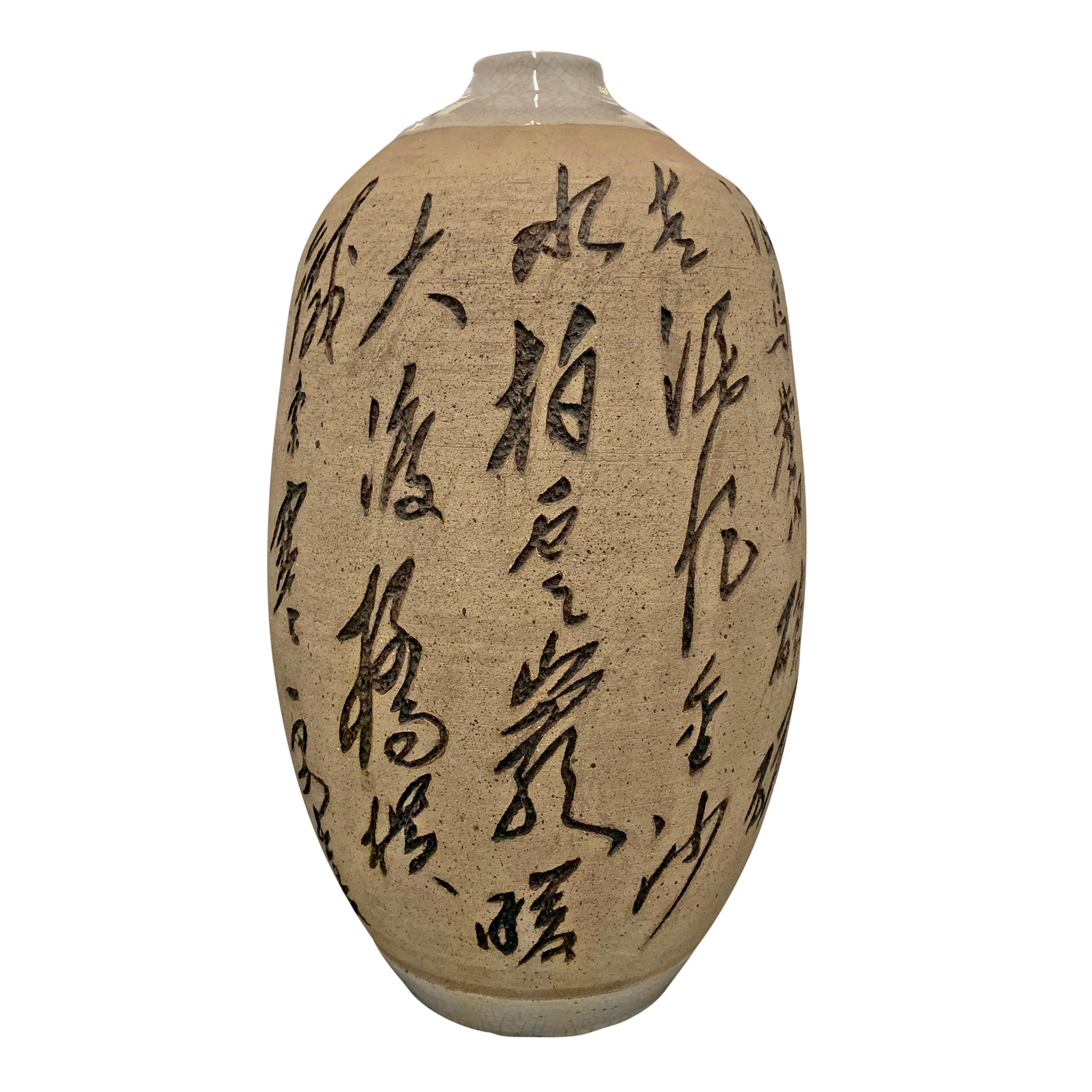 A fantastic large mid-20th century Chinese vase with heavily carved characters that complete part of a poem. The neck, bottom, and interior are glazed, while the center section and characters are unglazed.