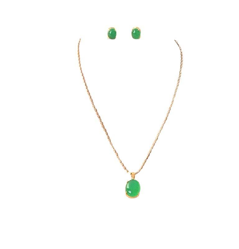 This chrysoprase pendant and matching earring set is mid-century Chinois. The large, bright green, translucent pendant stone measures 15.5mm long x 12mm wide. It hangs from a gold chain. The matching green chrysoprase earrings are pierced with