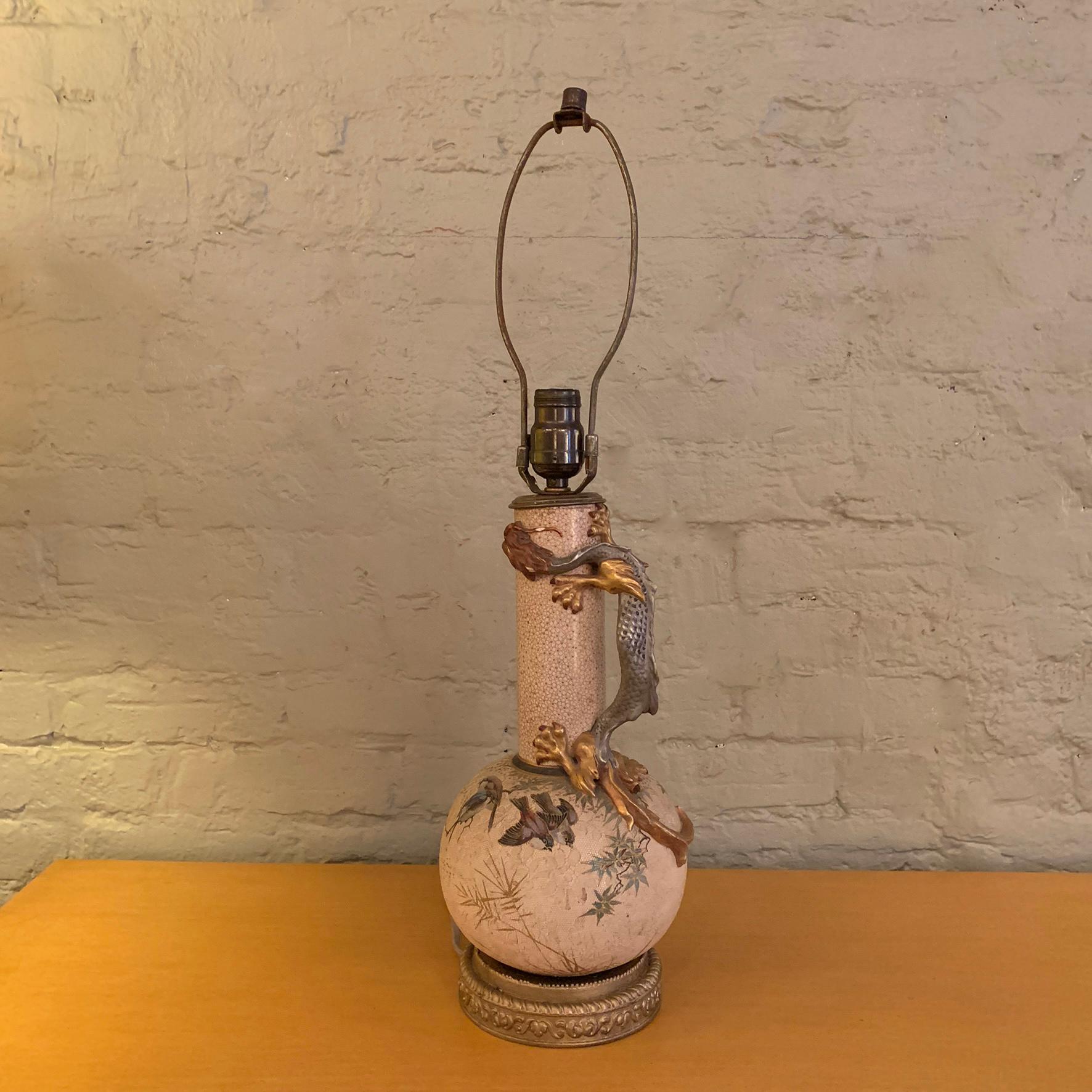 Midcentury, chinoiserie, plaster, table lamp depicting a dragon figure winding up it's faux marble textured stem, resting on it's lace textured, orb base. The height to the top of the socket is 17 inches. The lamp is attributed to Royal Worcester. 