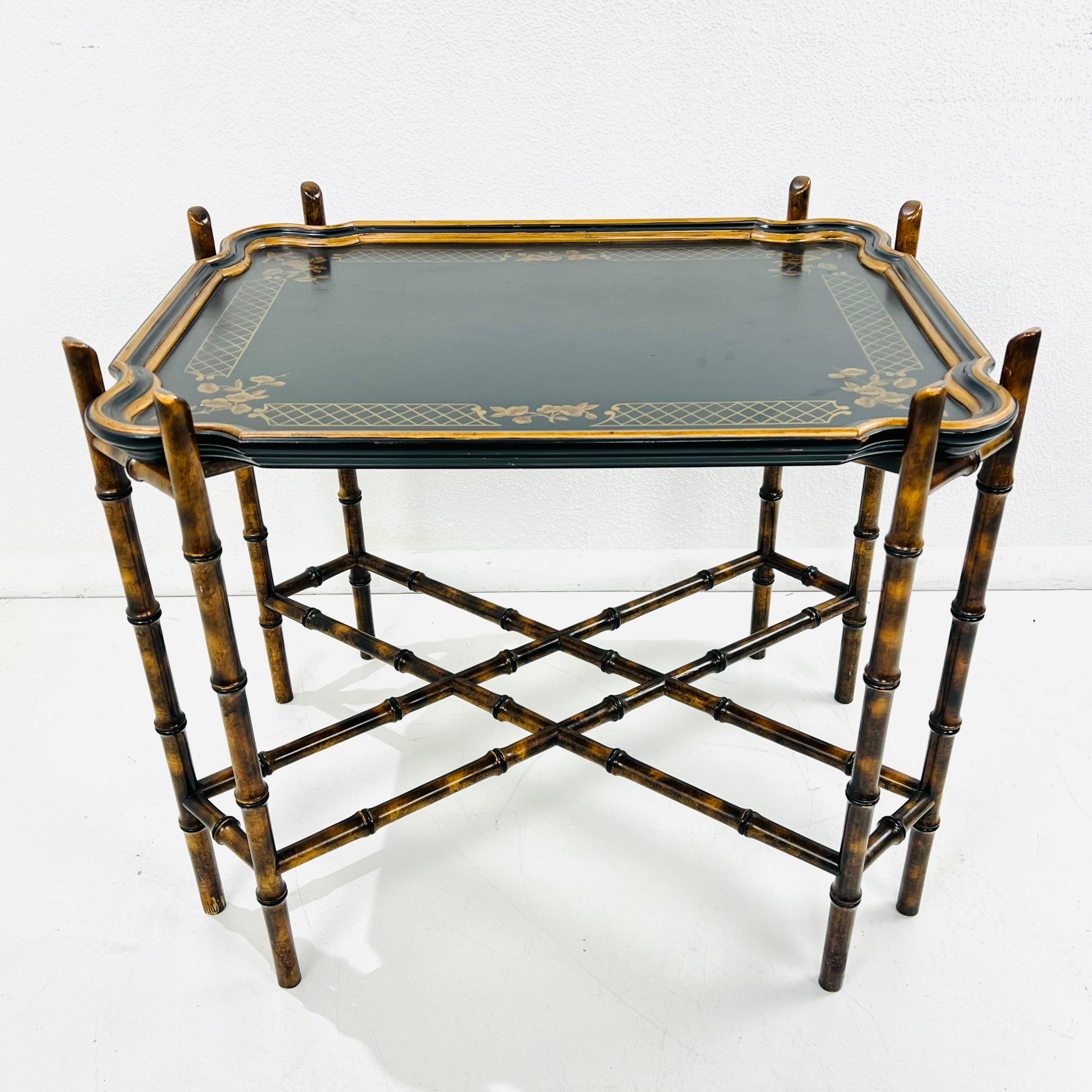 Vintage Mid-Century Tray Table featuring an Ebonized & gilded removable scalloped tray resting atop a solid cross brace faux bamboo stand hand painted to give a faux tortoiseshell finish.
Made by Baker Furniture in the late 1950s.

Table