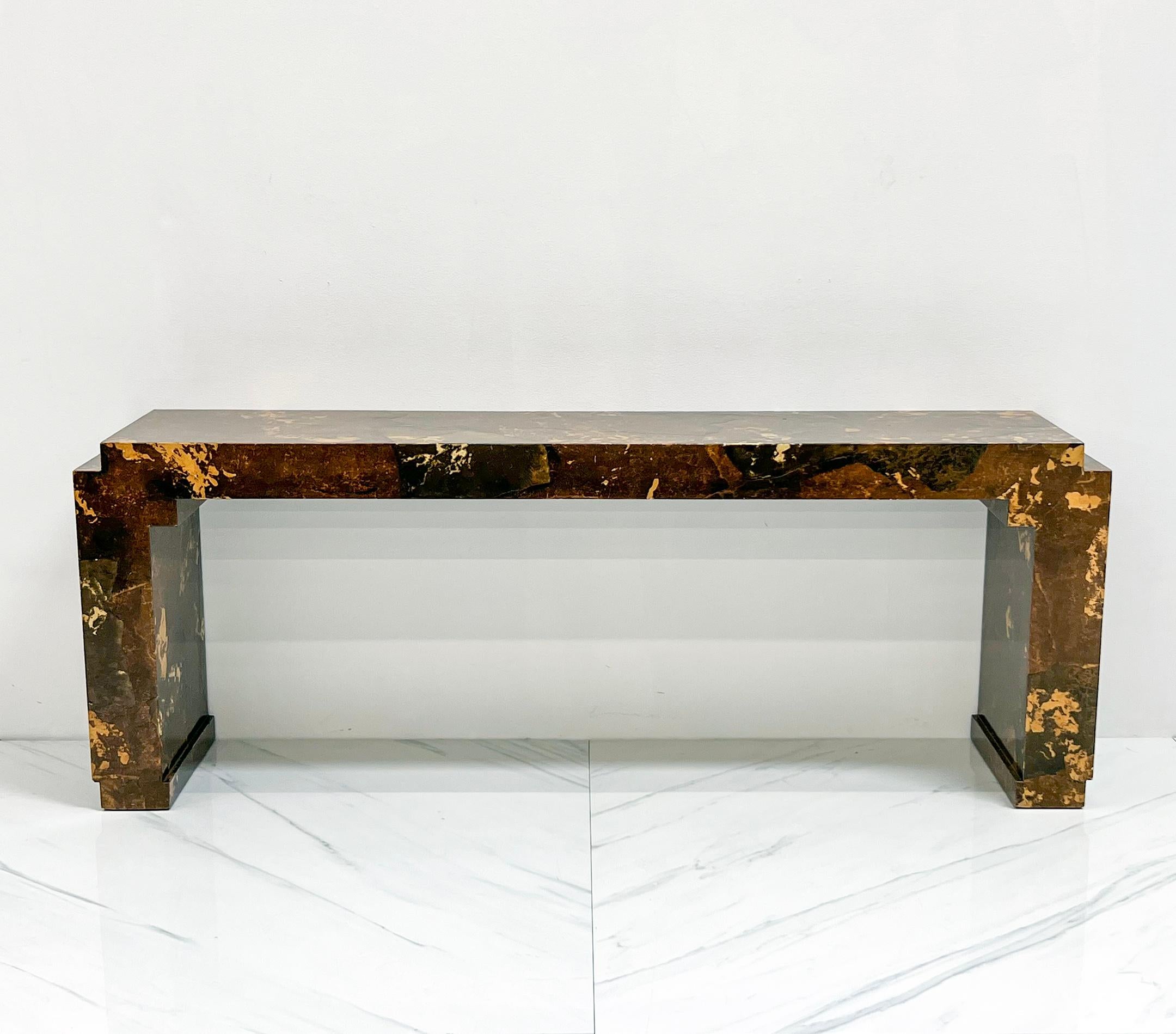 This table is absolutely gorgeous! Composed of solid wood clad with parchment paper and lacquered, this console table is timelessly chic with just a touch of chinoiserie.

The lacquered parchment is in browns, tans, and golden hues and almost has