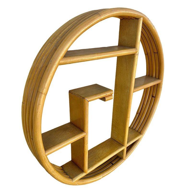 This beautifully restored Paul Frankl-inspired Mid-Century Chinoiserie Modern Round Rattan Shelf Wall Shelf with a round circular frame containing 5 tiers of wood shelves in asymmetric patterns. The shelf is reminiscent of the designs made famous by