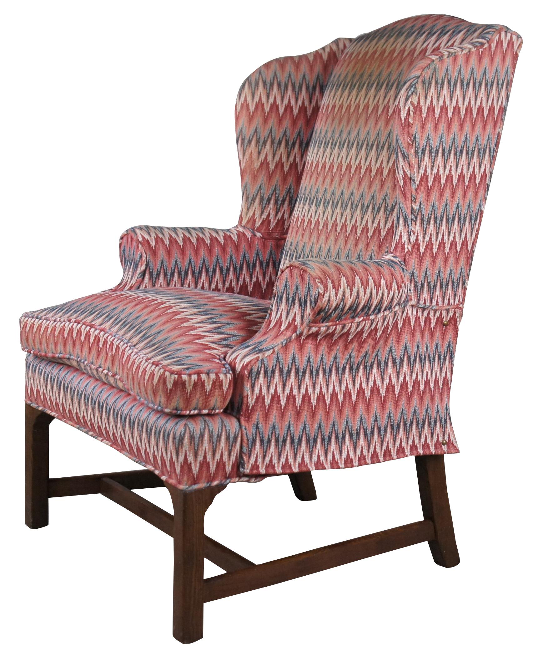 A beautiful traditional chippendale style wingback arm chair. Made from oak with a colorful chevron upholsterry and removable downfilled cushion. The chair features rolled arms and is supported by straight legs along the front connected to saber