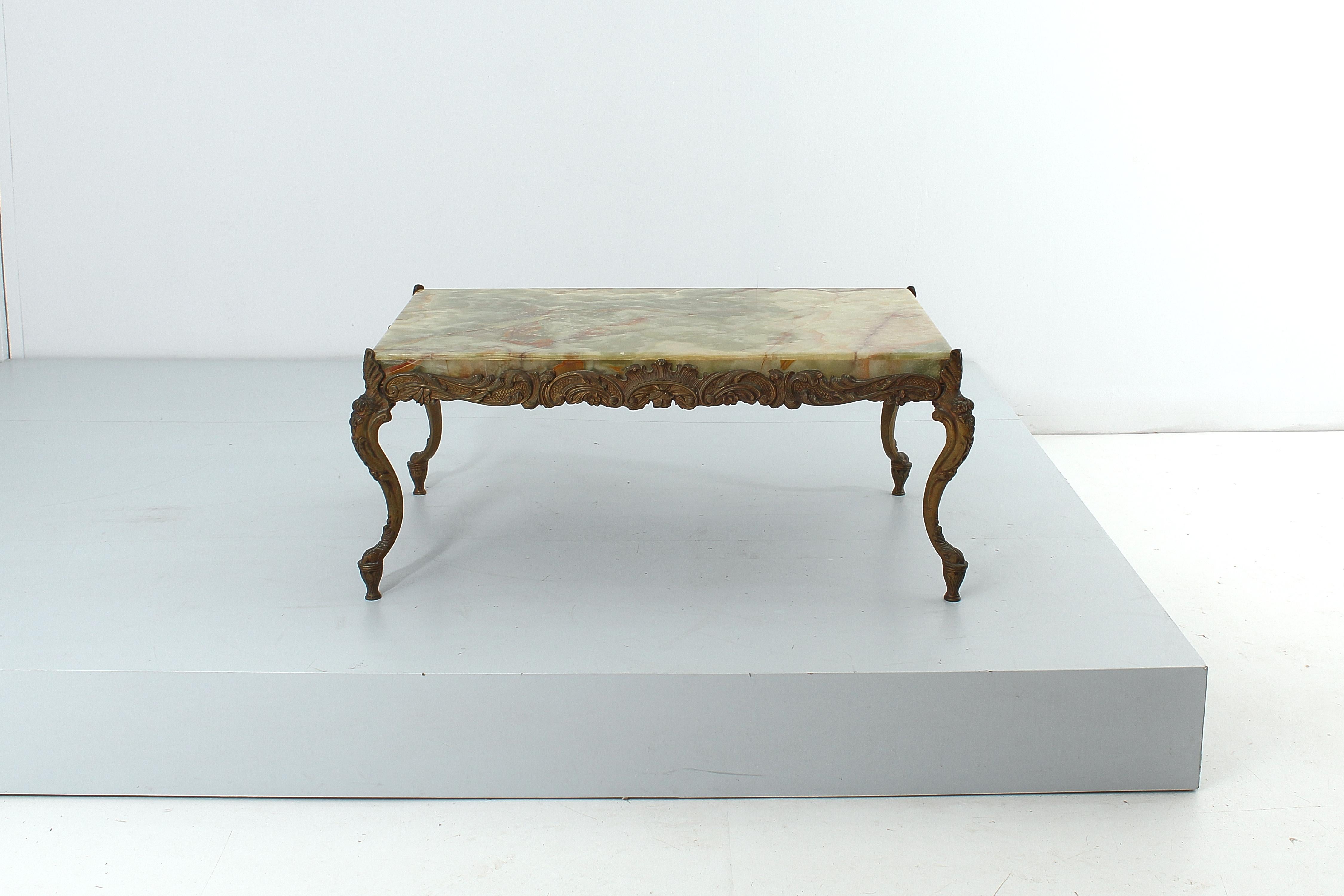 Table basse rectangulaire de style Chippendale avec plateau en onyx et structure en bronze avec décorations en relief. Fabrication italienne, années 1950. 
Usure conforme à l'âge et à l'utilisation.